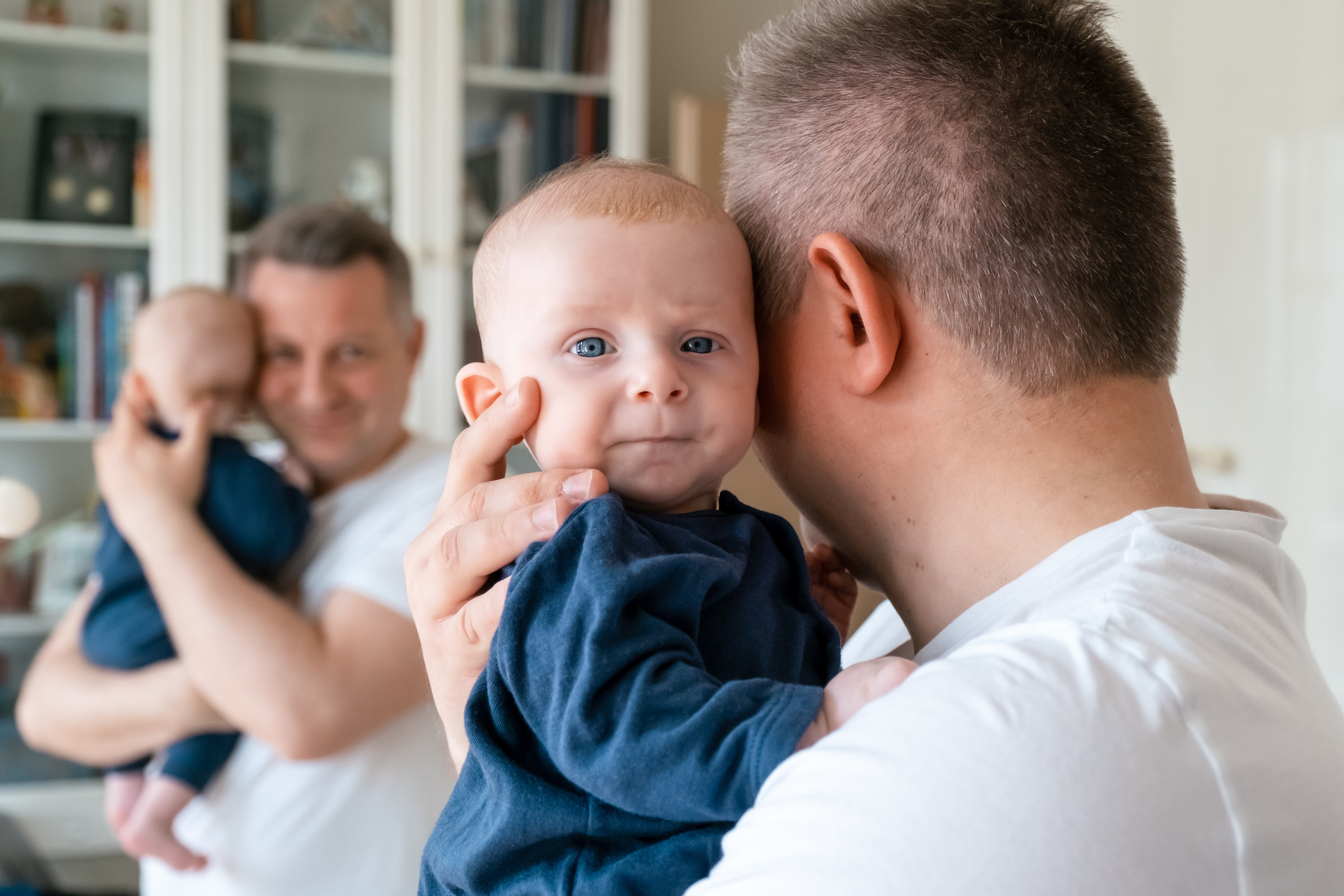 Папа держит малыша на руках, малыш смотрит на нас