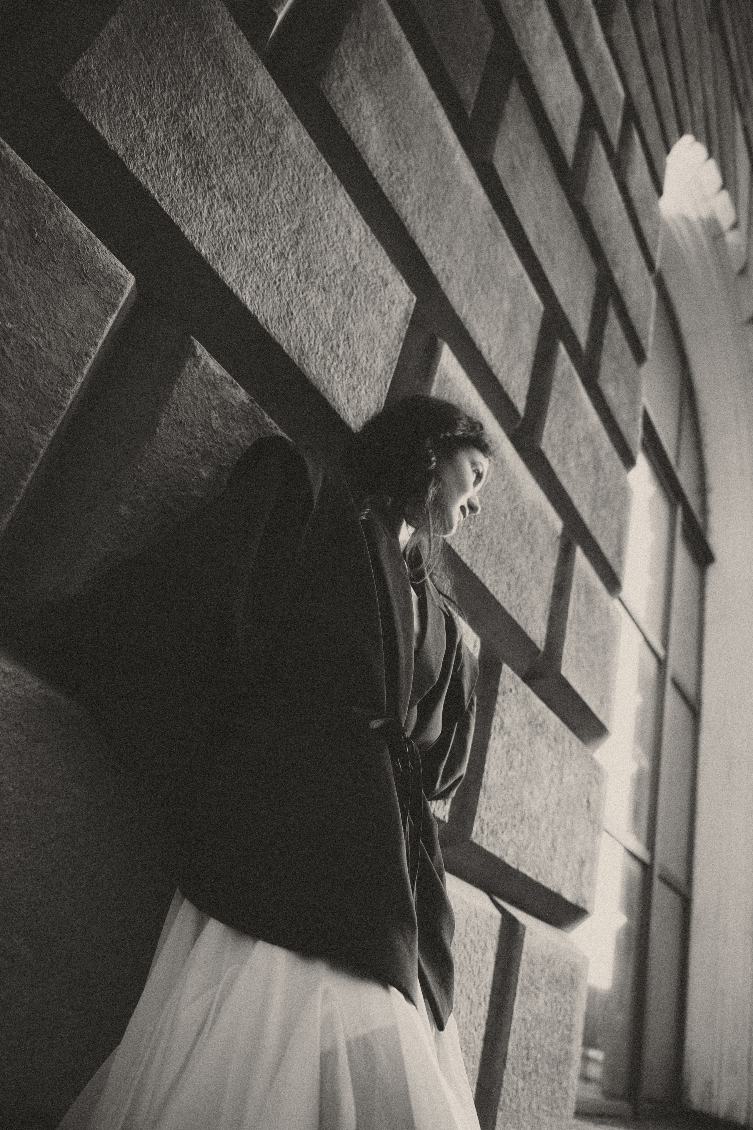 черно-белый портрет девушки на фоне старого здания