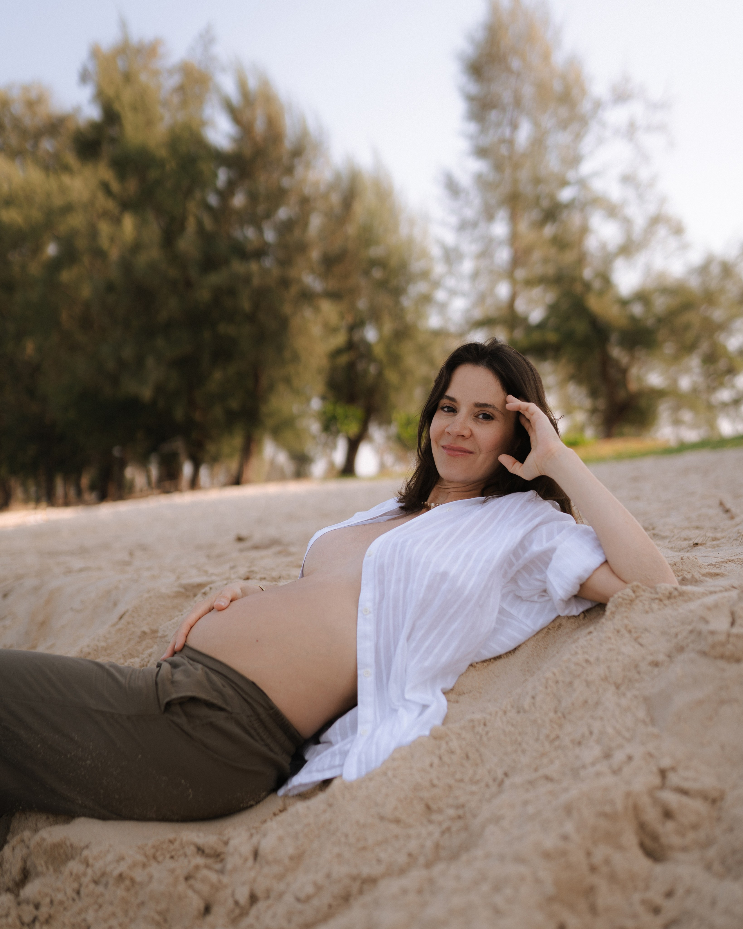 Девушка лежит на песке у моря