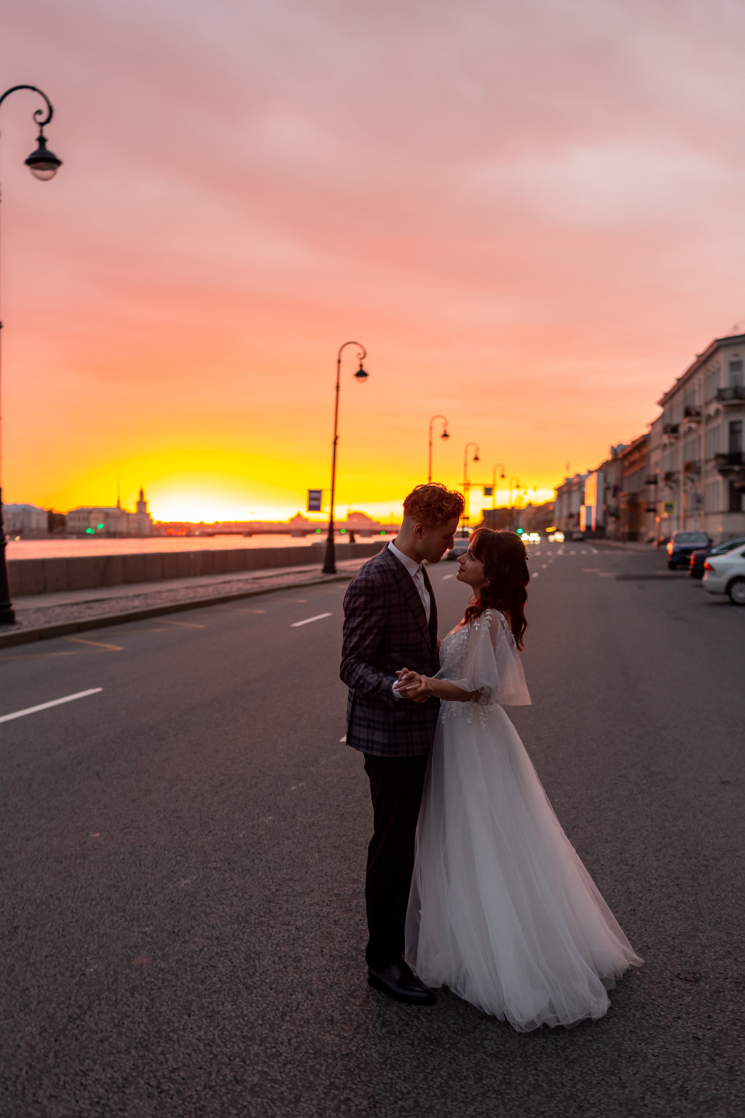 Невеста в платье с фатой идёт по городу