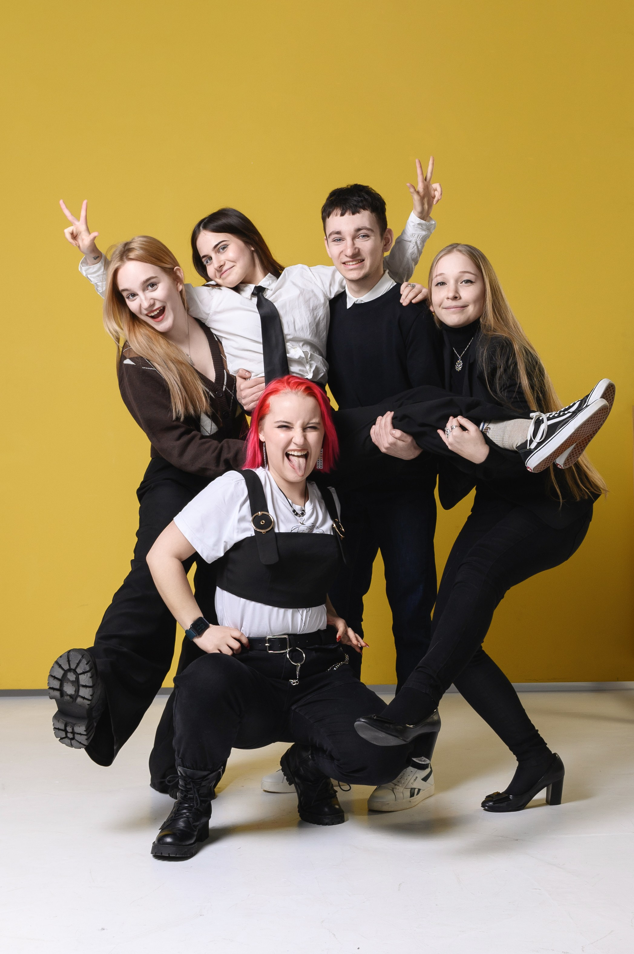 Групповой кадр с друзьями на жёлтом фоне в энергичной позе для выпускной серии.