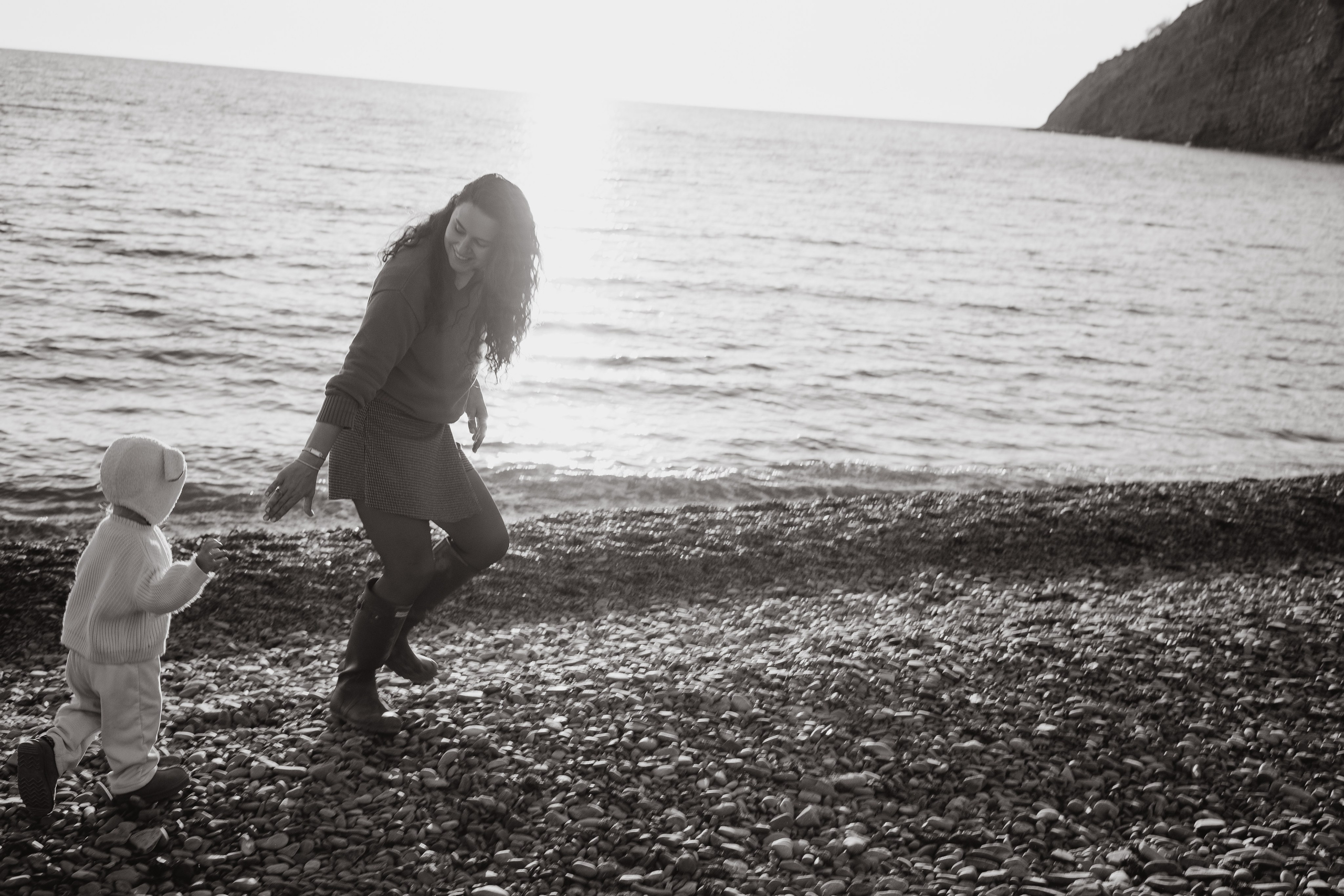 Искренний смех и объятия семьи во время фотосессии у моря