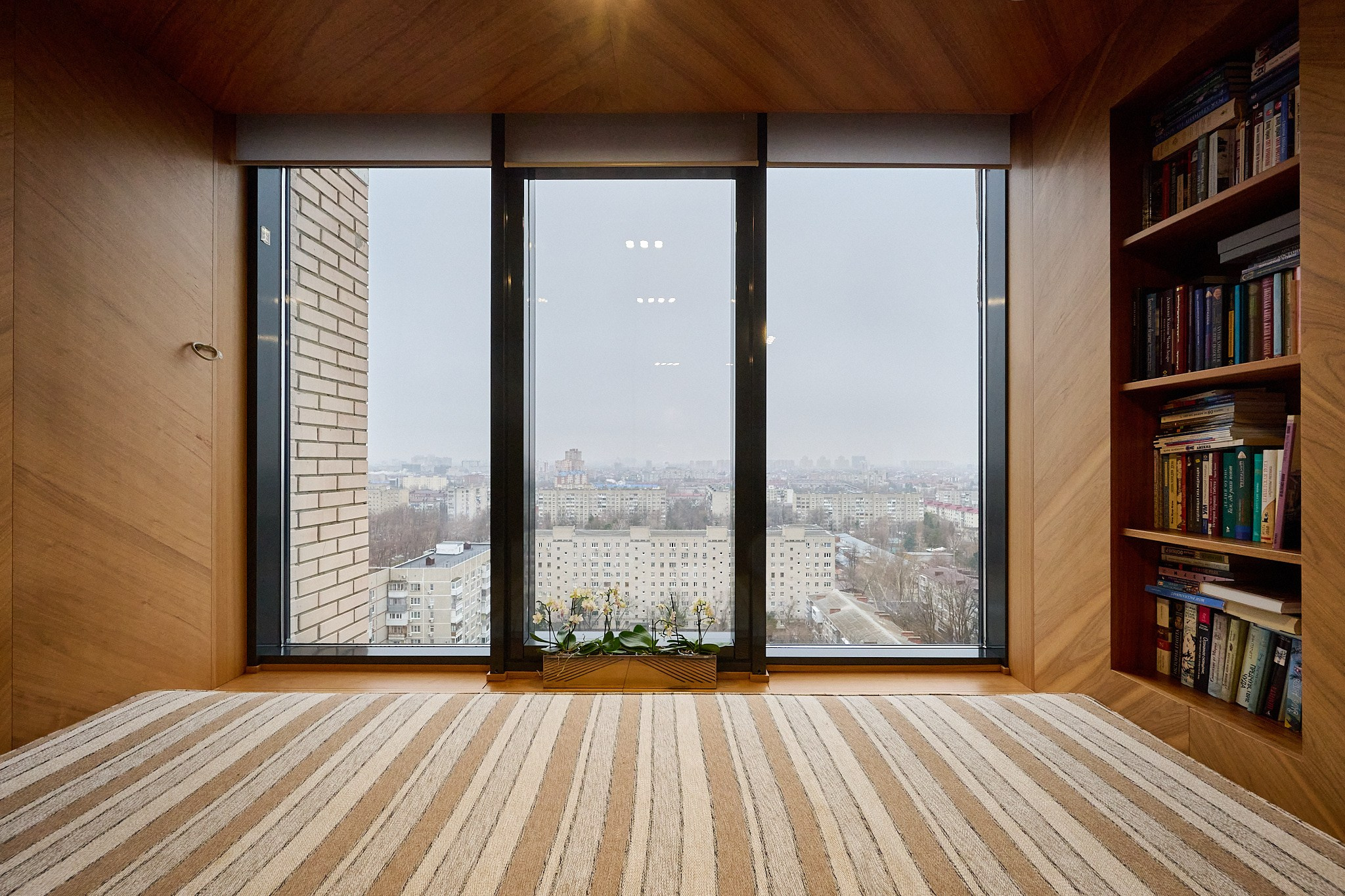 балкон с окнами до пола деревянные стены шкаф для книг 