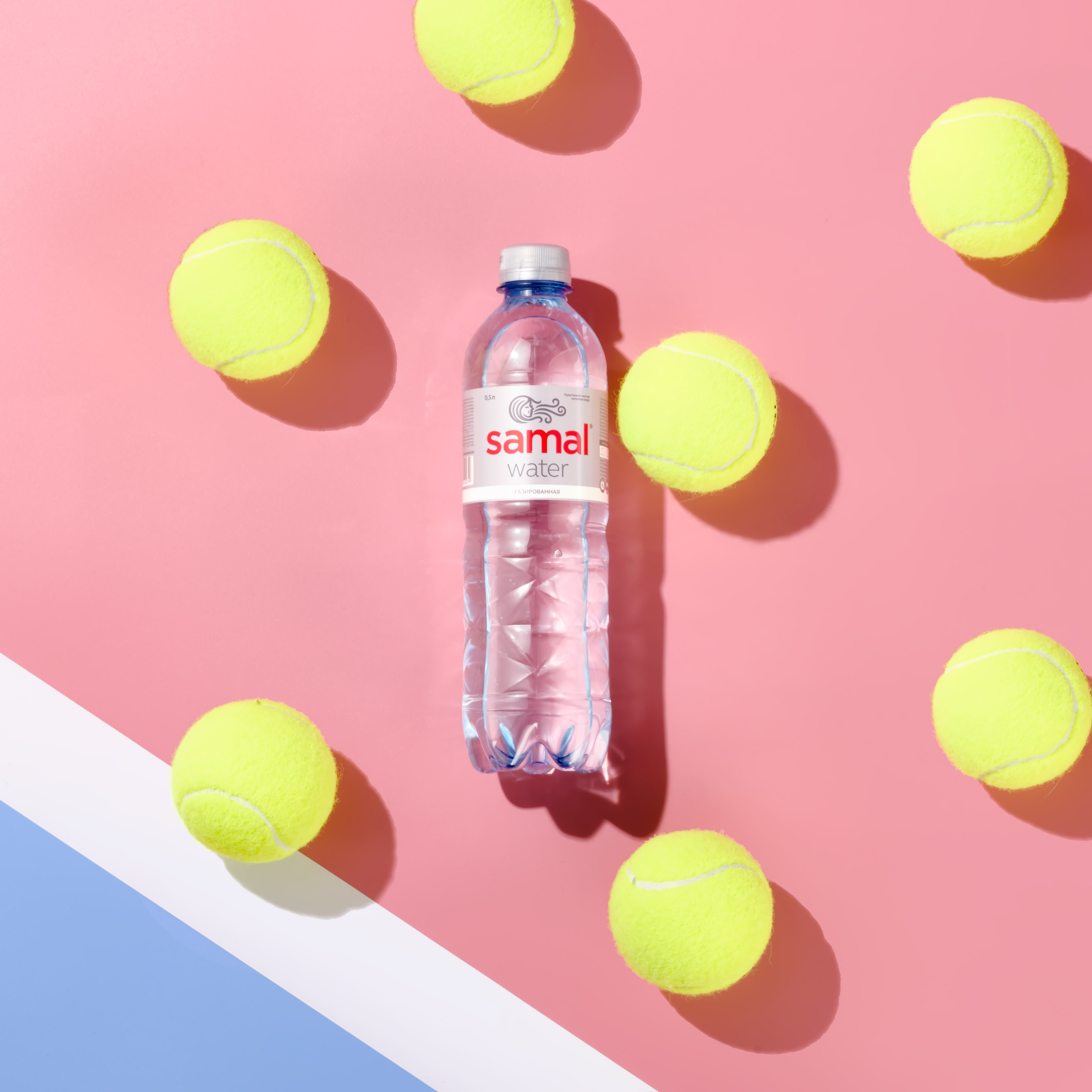 Контентная фотосъёмка воды SAMAL в Алматы — имиджевое фото с теннисными мячами.