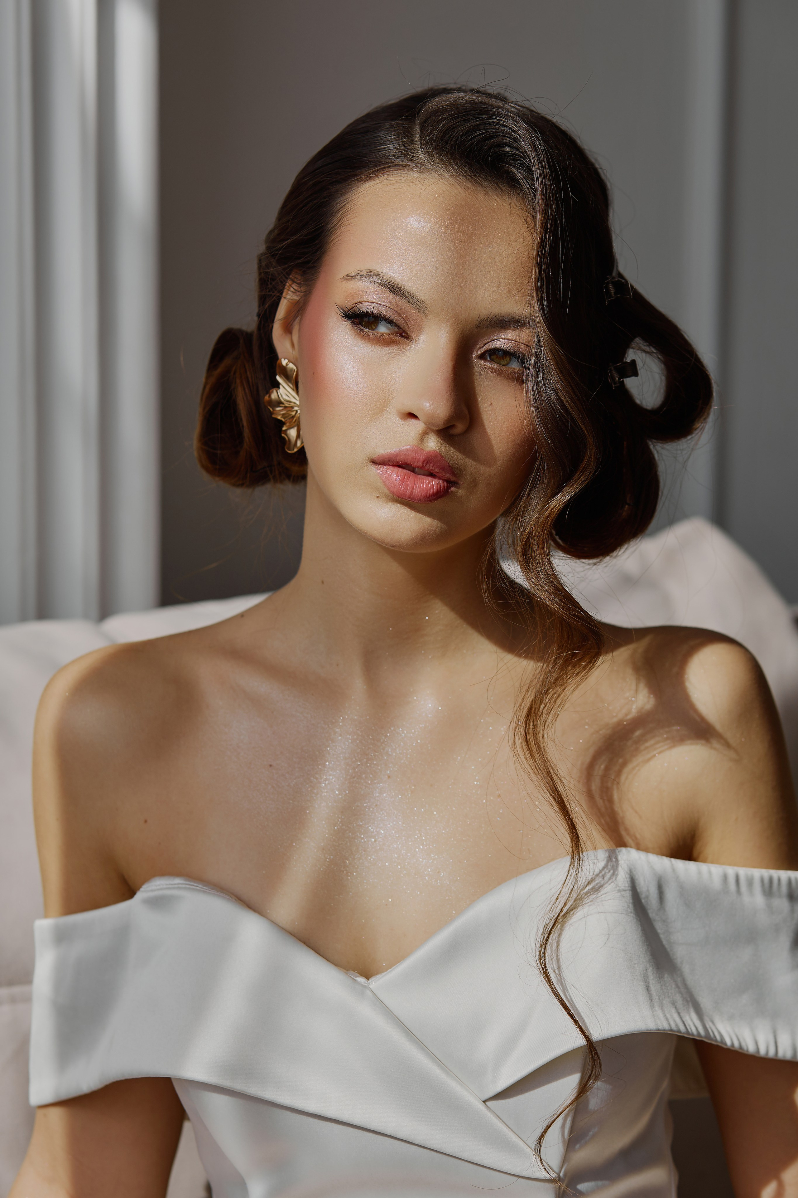 Портрет девушки брюнетки в белом платье в лучах солнца, проходящих через окно в Анапе.