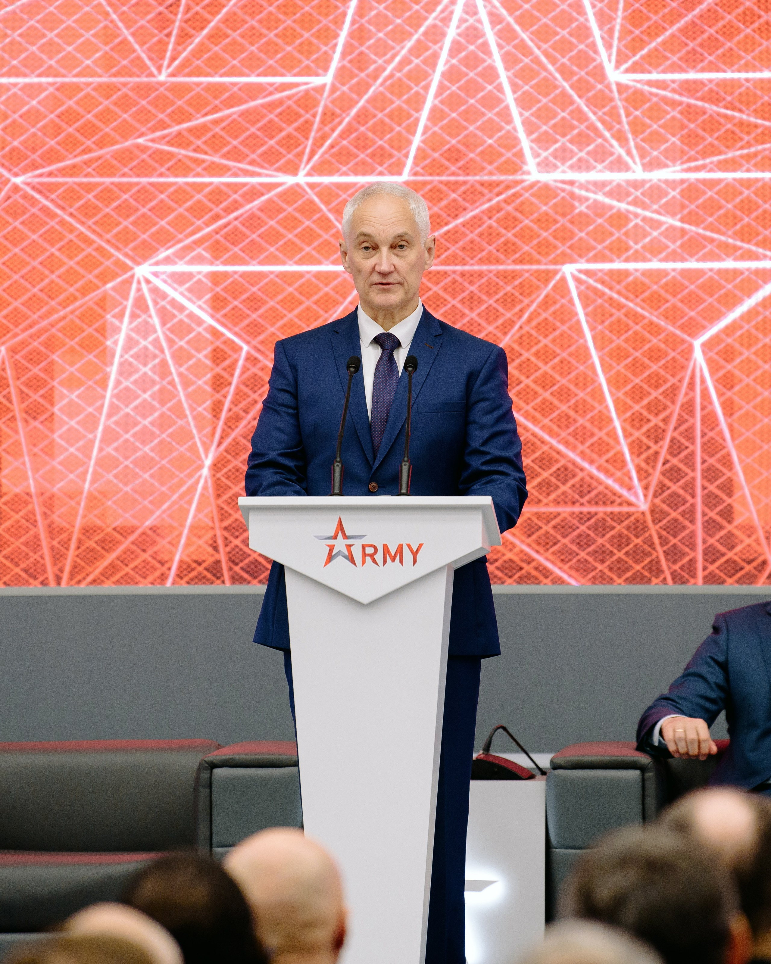 Фотография с выставки, на которой изображены участники, обсуждающие экспонаты.  Фотография репортажного характера, запечатлевшая важный момент корпоративного мероприятия. Министр обороны РФ Белоусов. Чемезов Роснано. Армия 2024. Вероника Скворцова