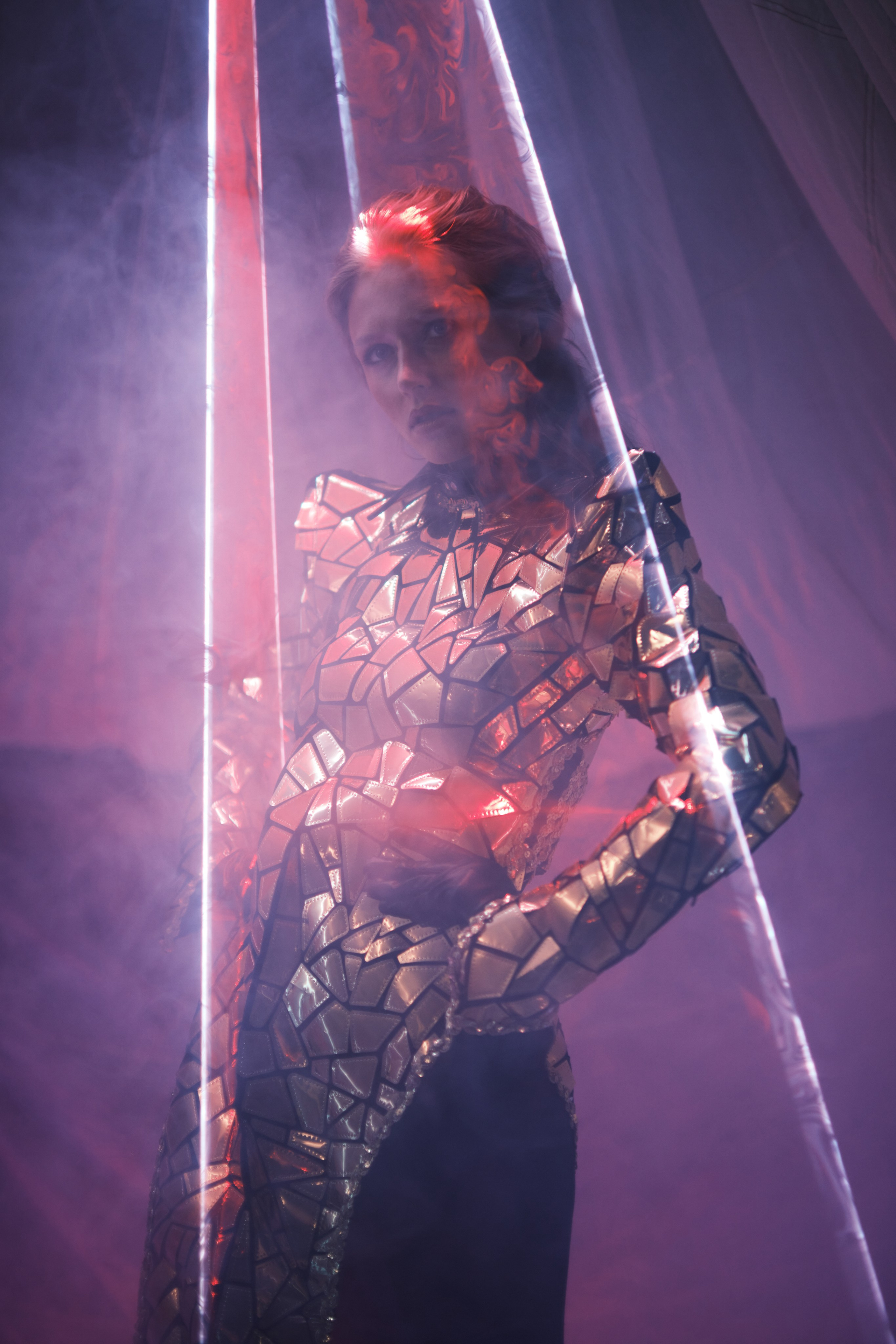 Фотосессия в стиле футуристической моды девушка в зеркальном костюме с отражения лазера