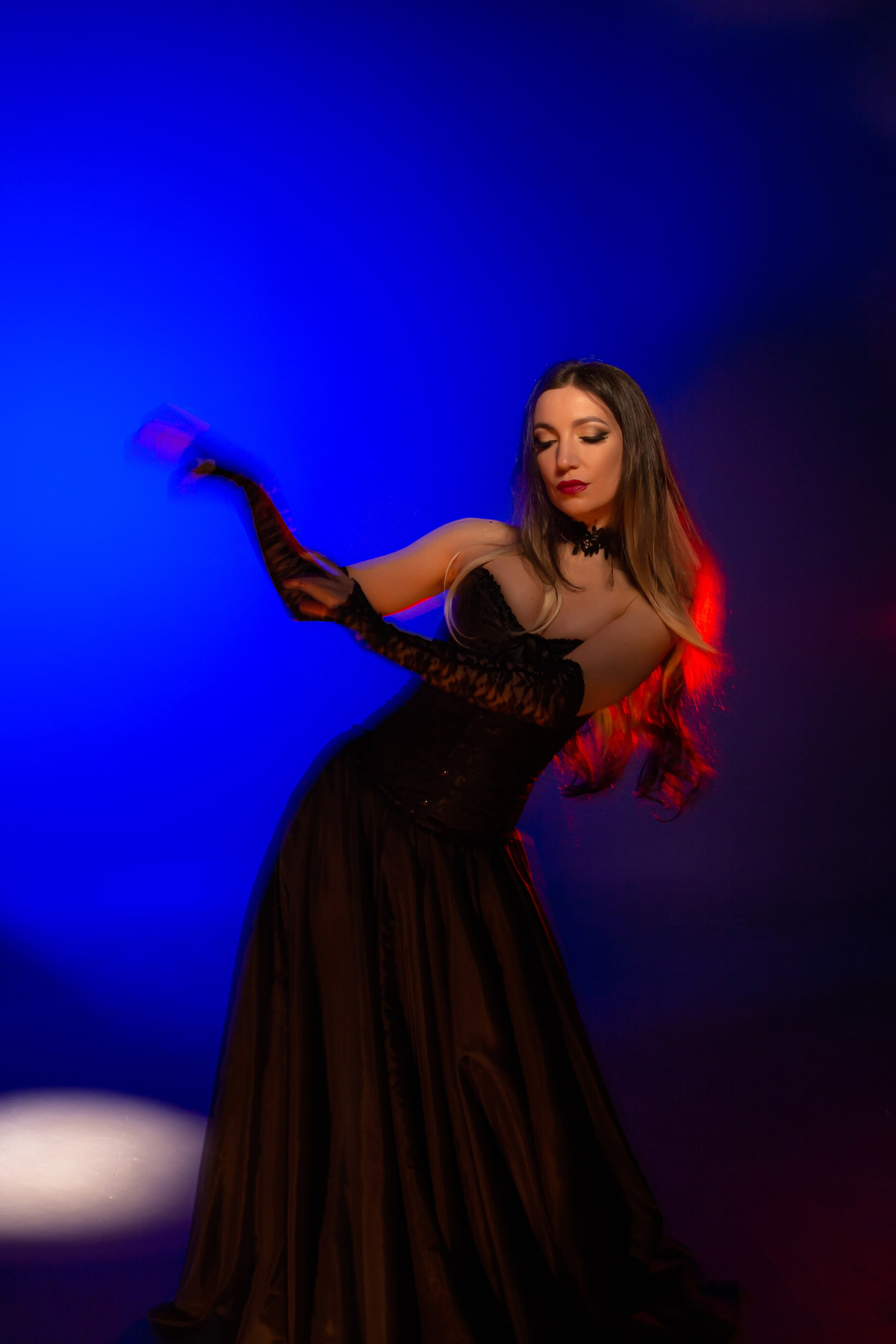 Лирика цветов и света: сочетание красного, синего, бирюзового и розового освещения в технике смешанного света подчеркивает нежность и эмоциональность портрета девушки