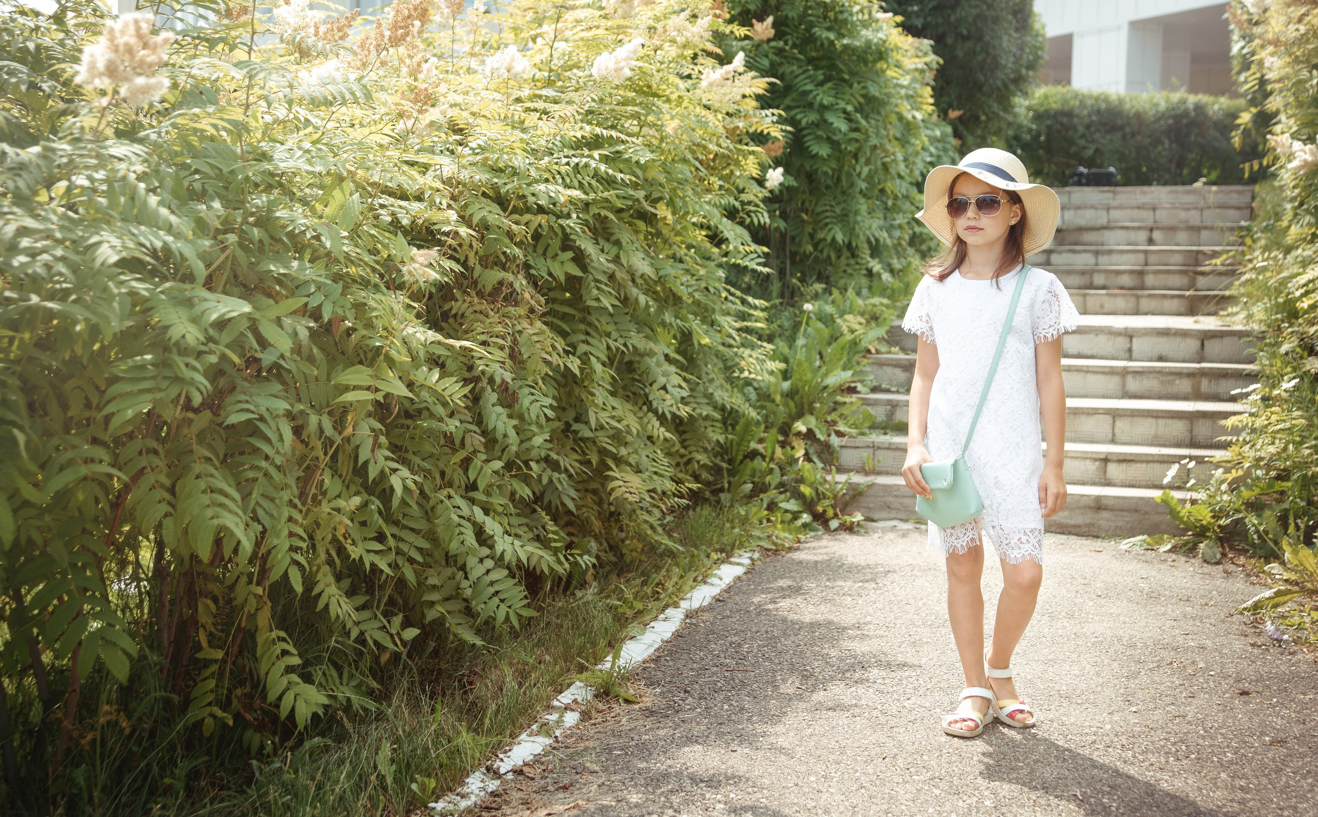 Детская фотосессия летом - девочка гуляя по парку