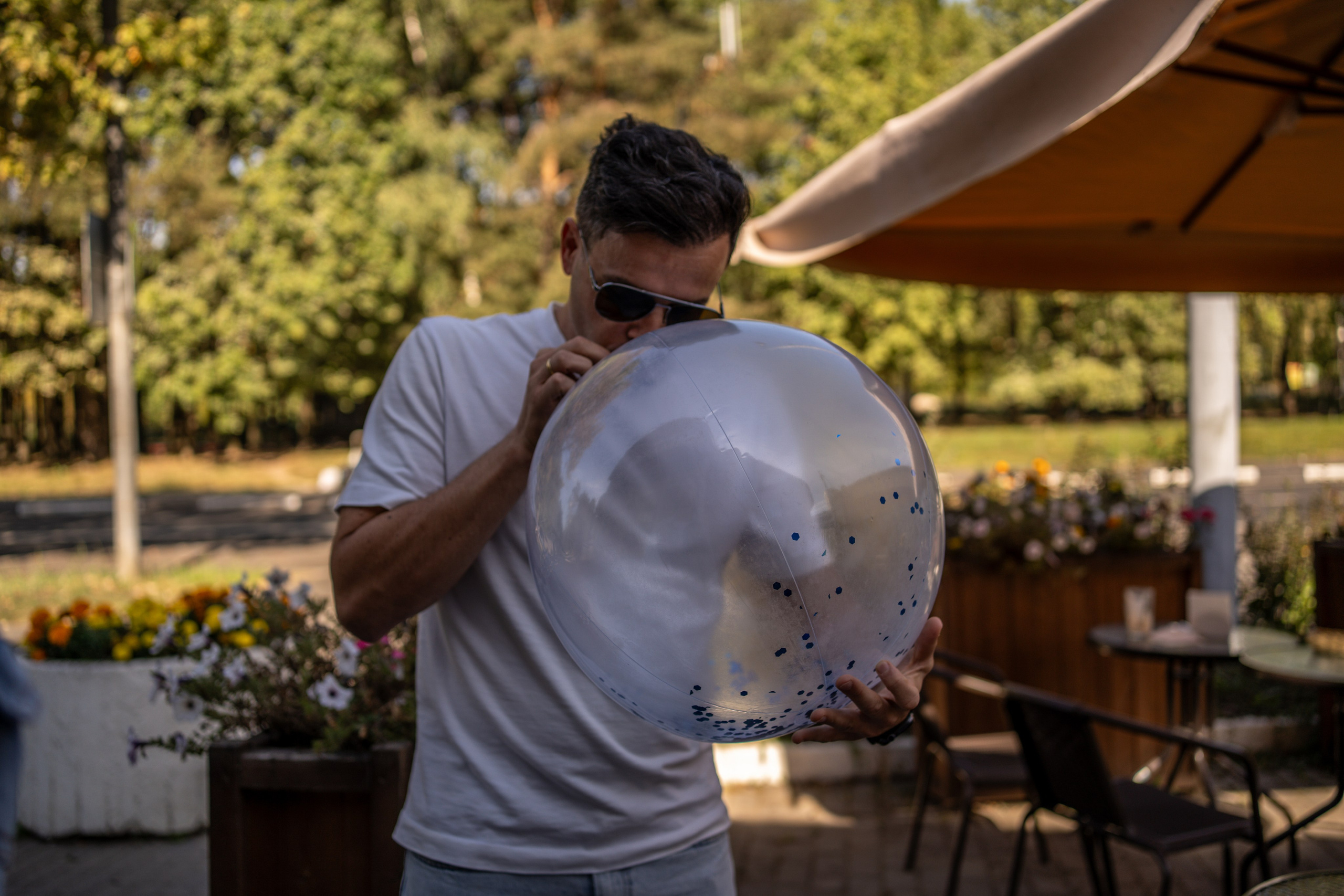 Мужчина надувает шарик