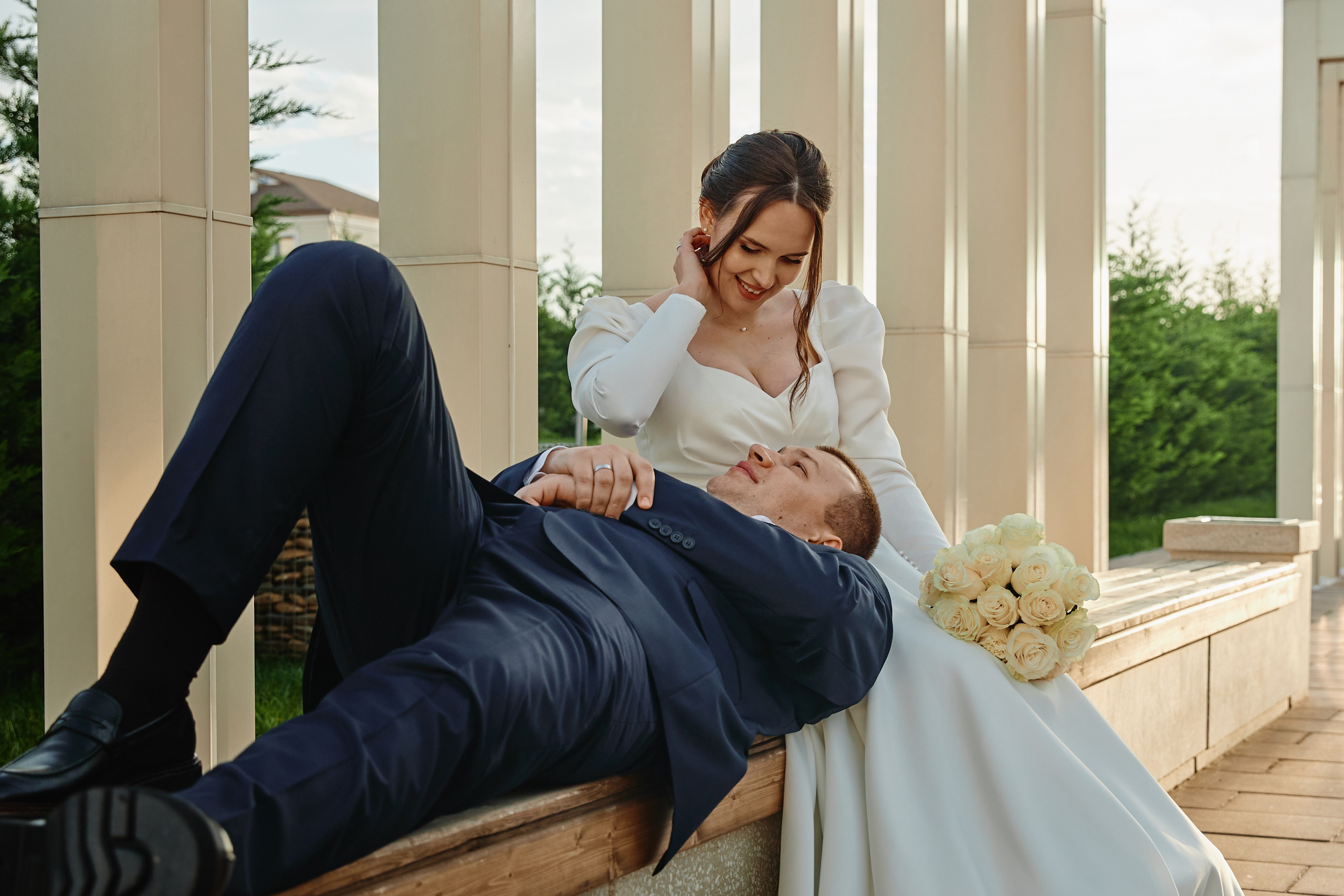 Свадебная фотосессия жених лежит на коленях невесты