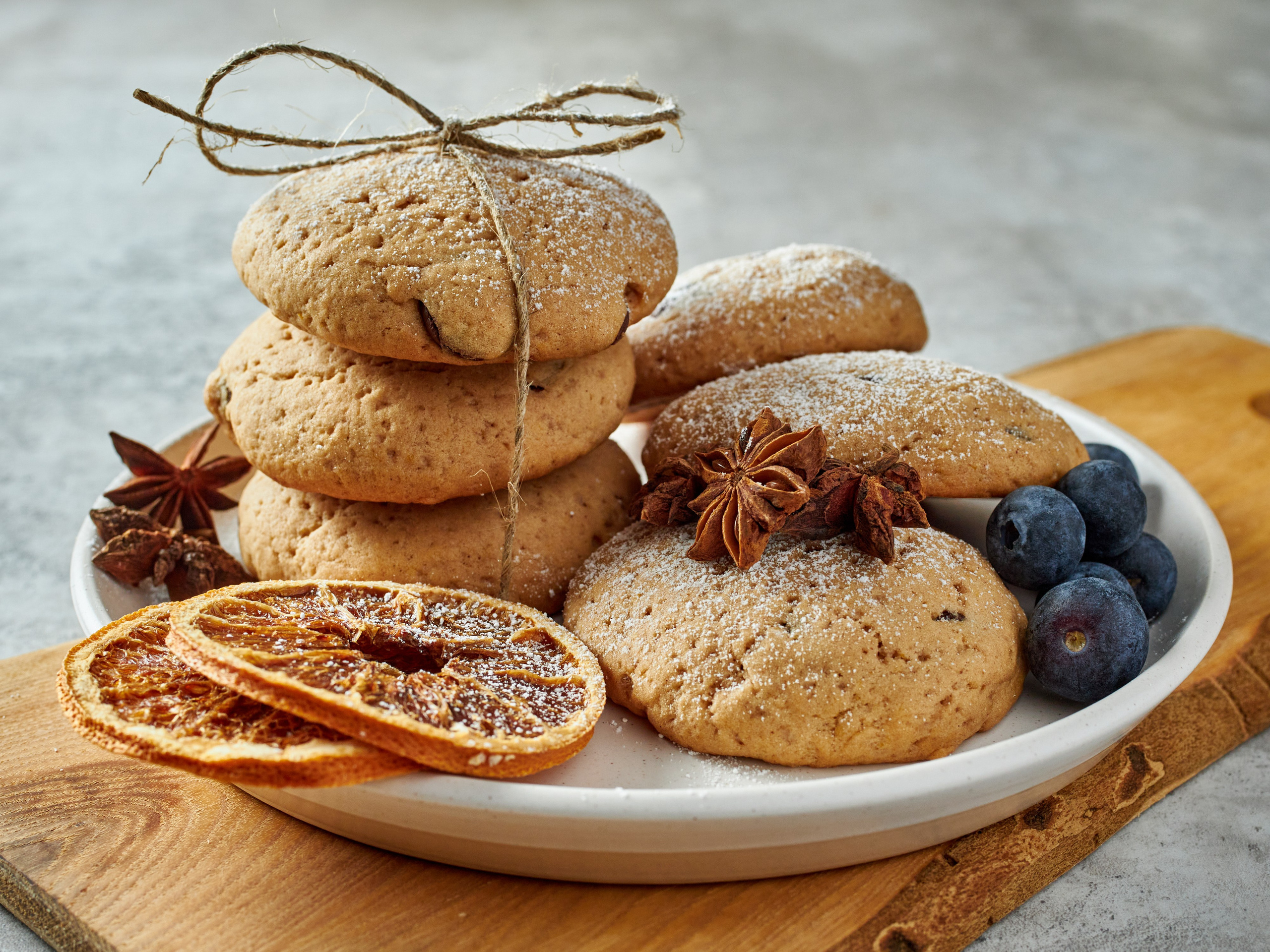 Имбирное печенье, голубика и сушеный апельсин в тарелке