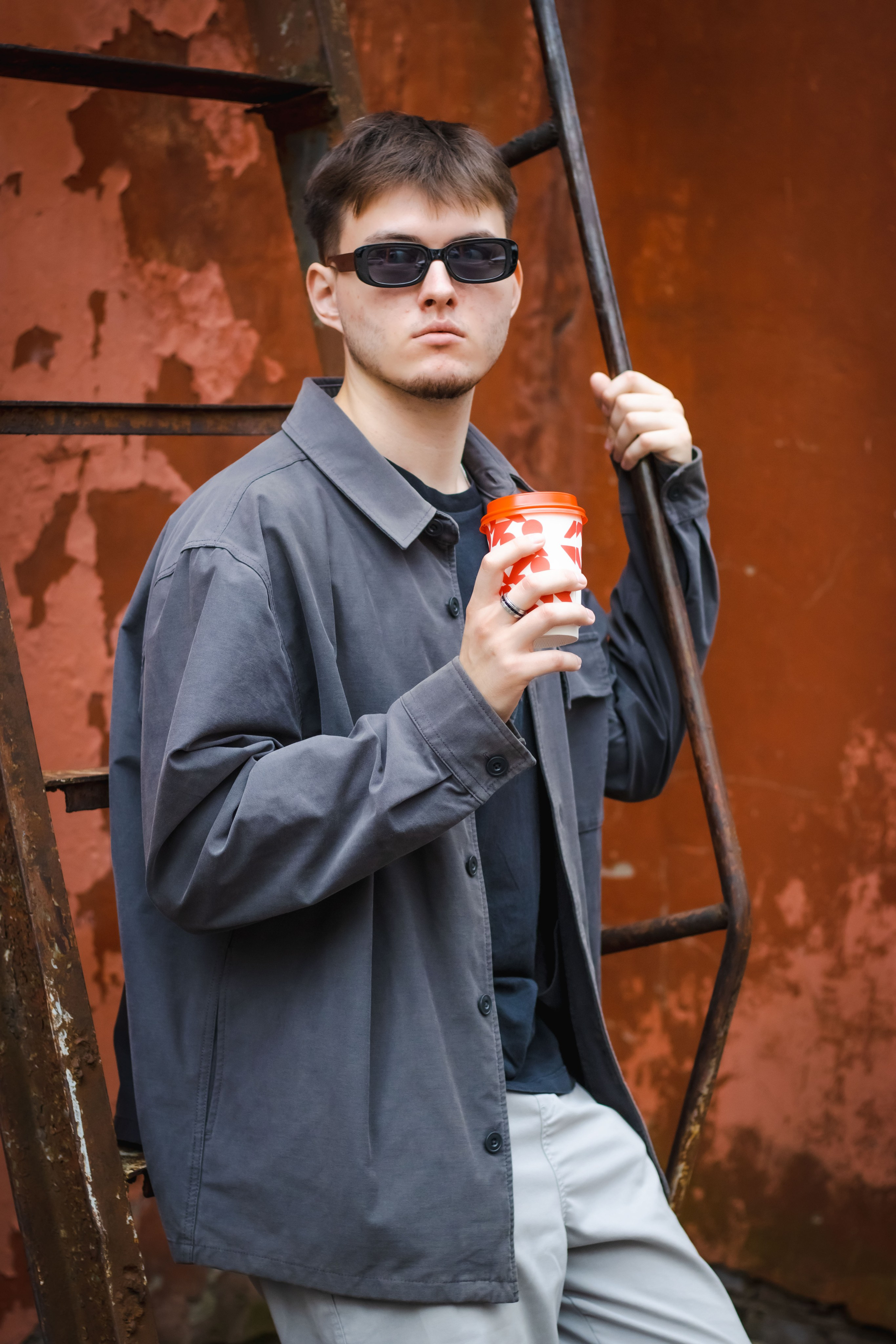 парень пьет кофе на улице