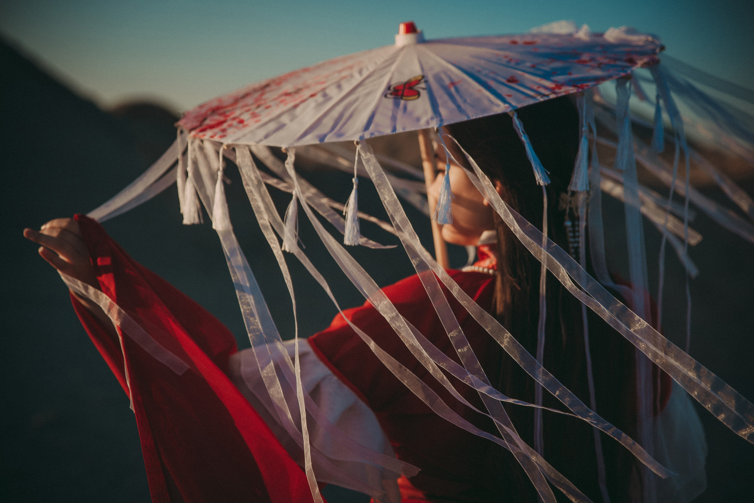 девушка прячется от солнца под зонтом