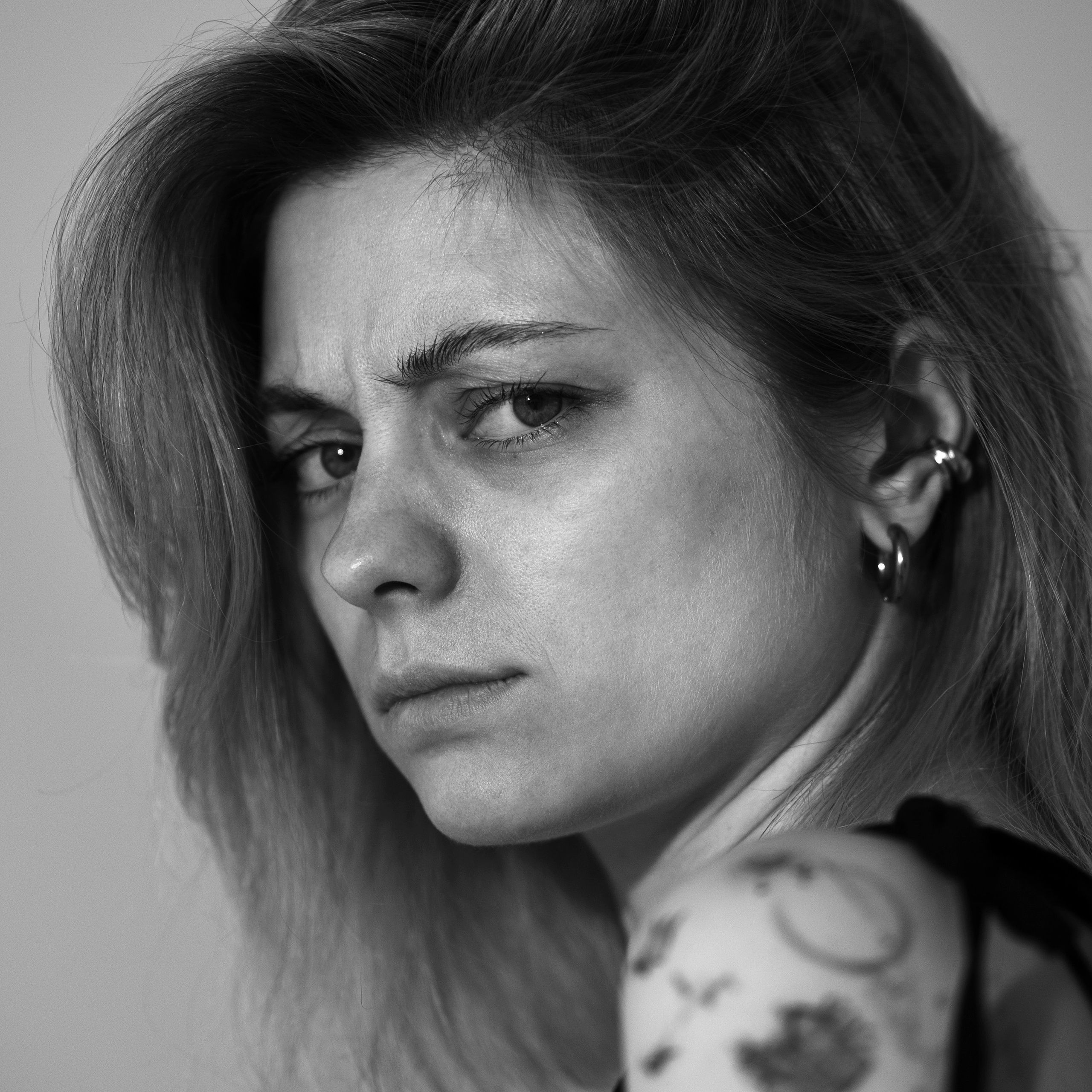 Черно-белый портрет хмурящейся светловолосой девушки