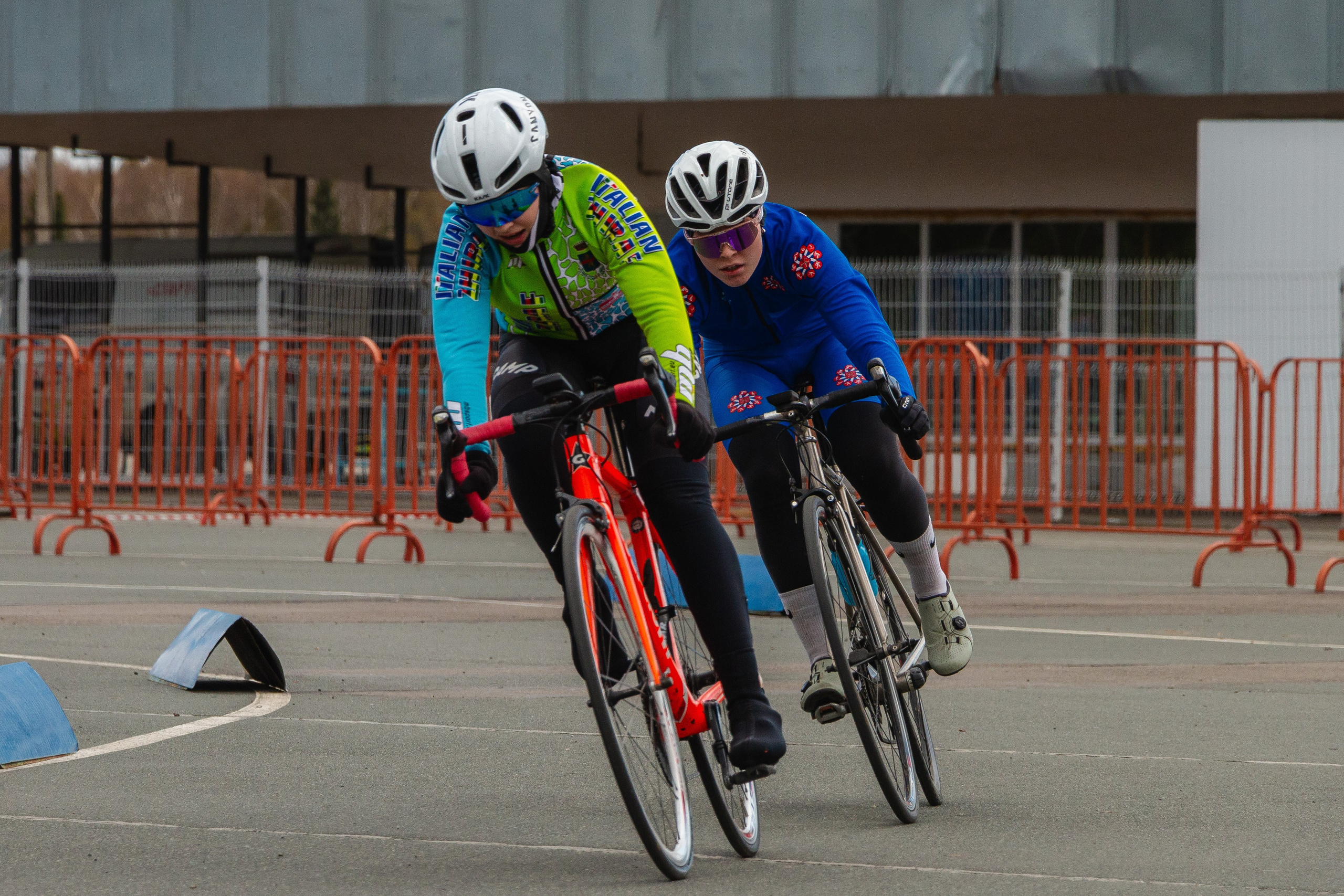 Велогонщики немного наклонившись входят в поворот