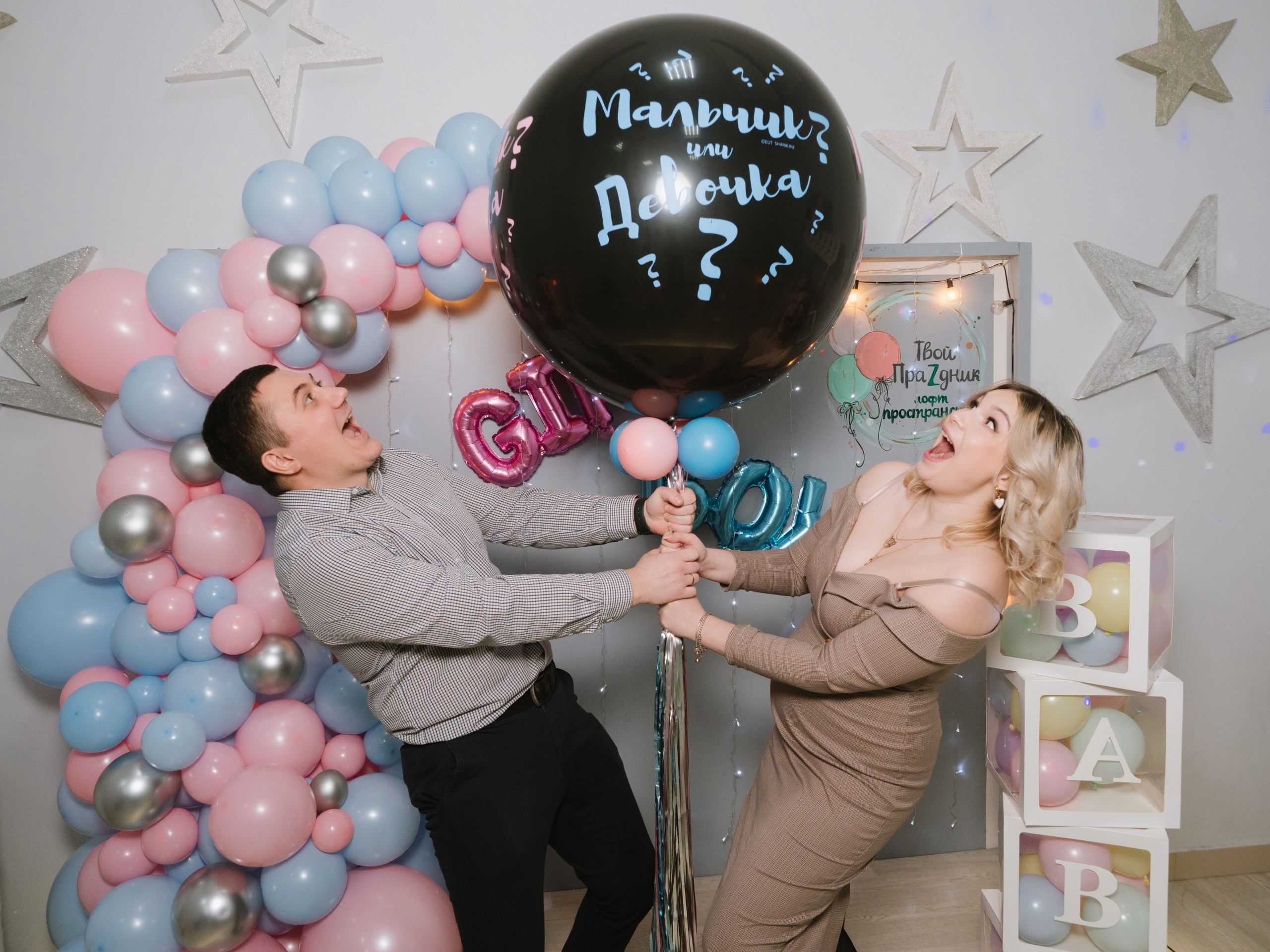 Мужи и жена держат шар на гендер пати в Москве