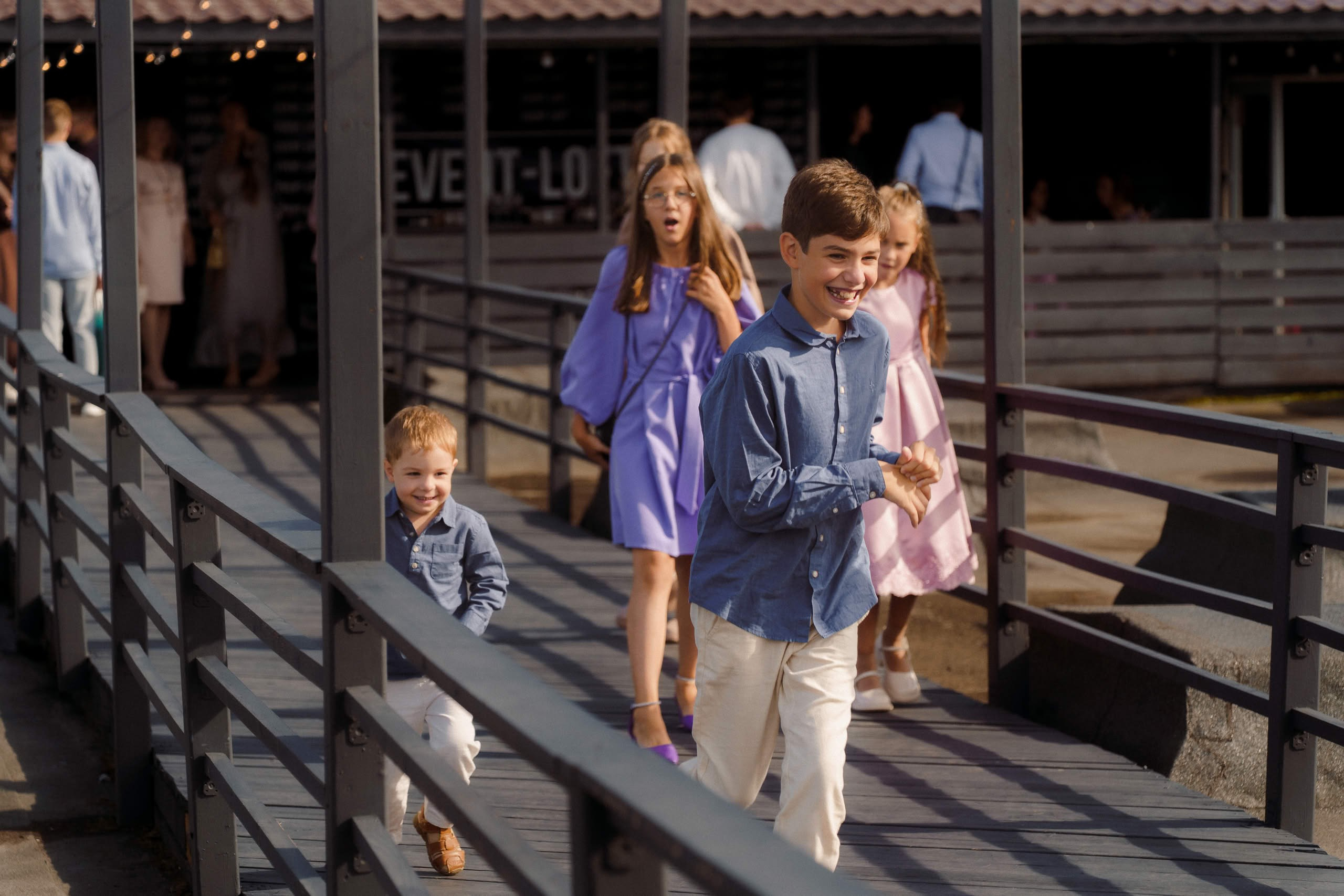 Свадебные гости и дети гуляют по террасе Event Rest в Петербурге