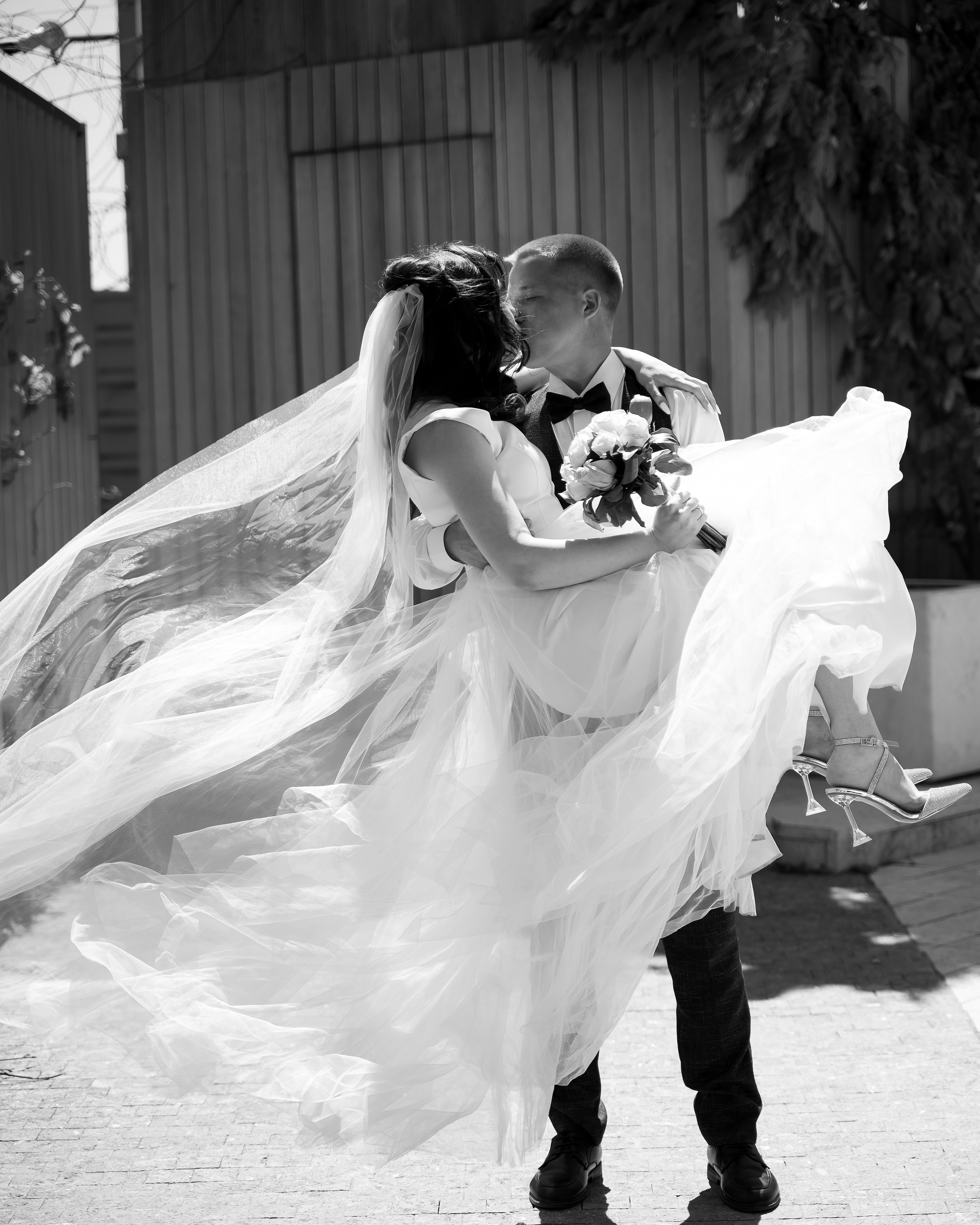 Жених несет невесту на руках.