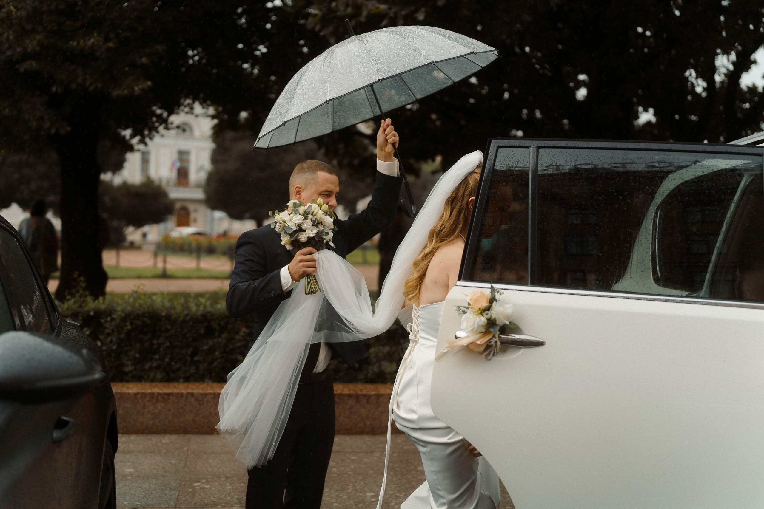 Невеста садится в автомобиль во время дождя — свадебная съёмка в Санкт-Петербурге