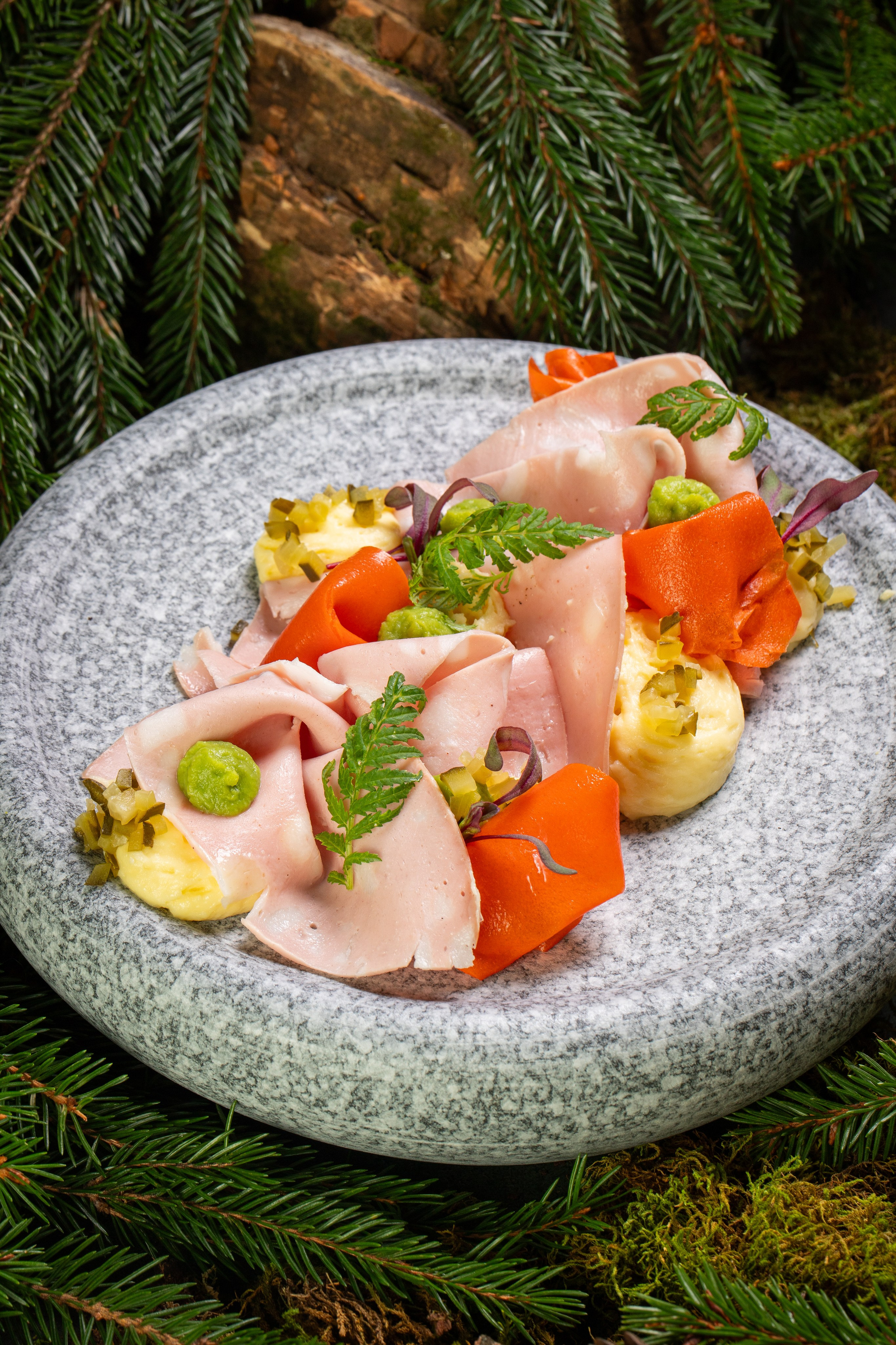 Салат оливье на красивой тарелке из камня. Лесная композиция