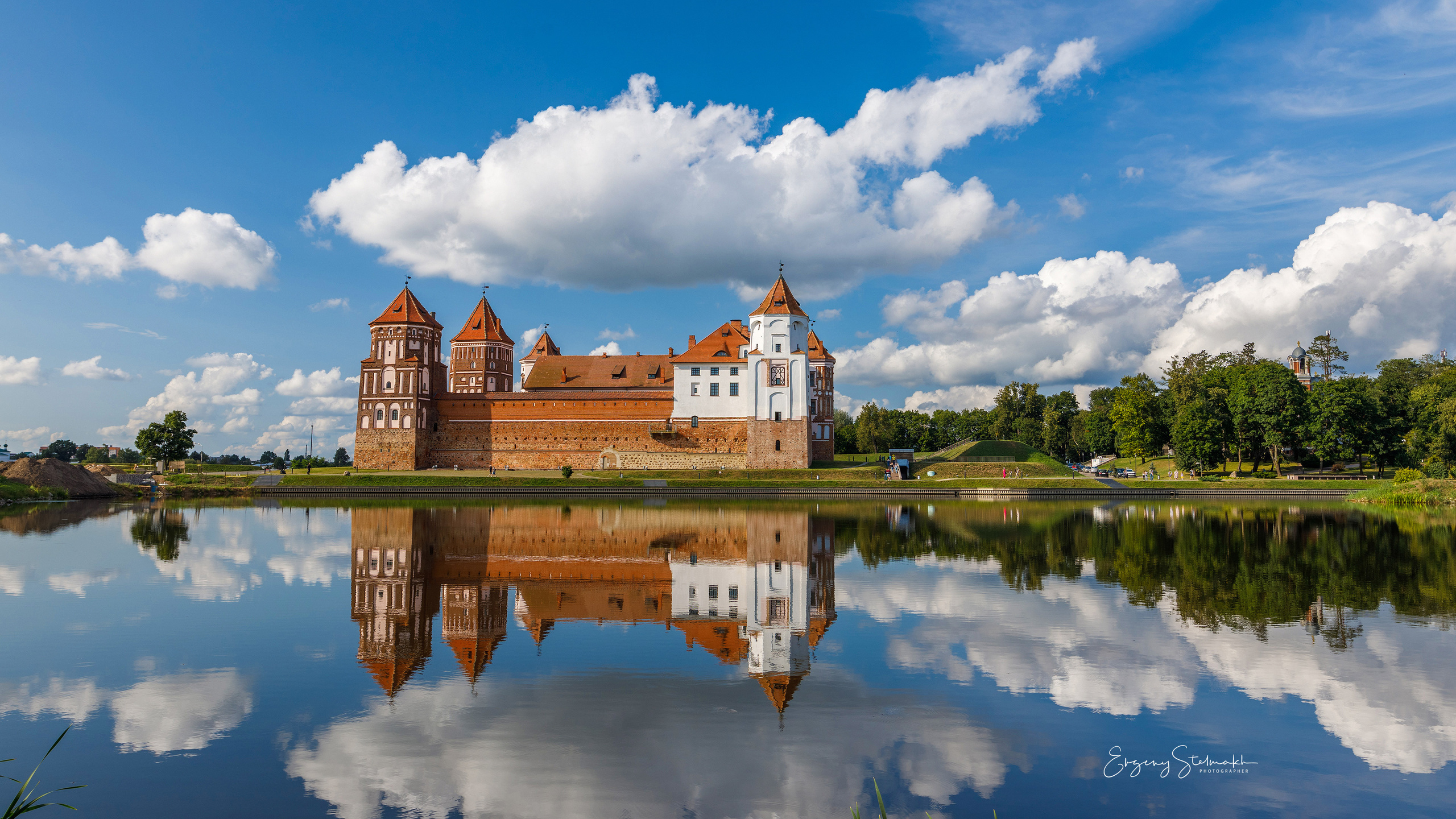 Мирский замок отражается в воде пруда.