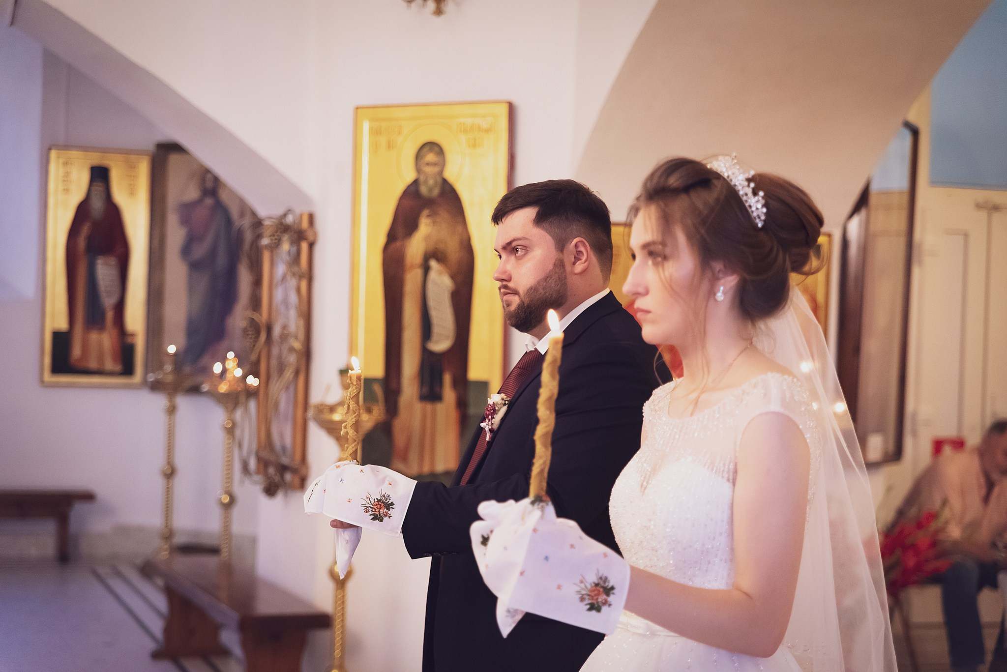 Фотограф Оксана Лавренюк - фотосъемка венчания в Краснодаре Священник благословляет пару двумя зажженными свечами