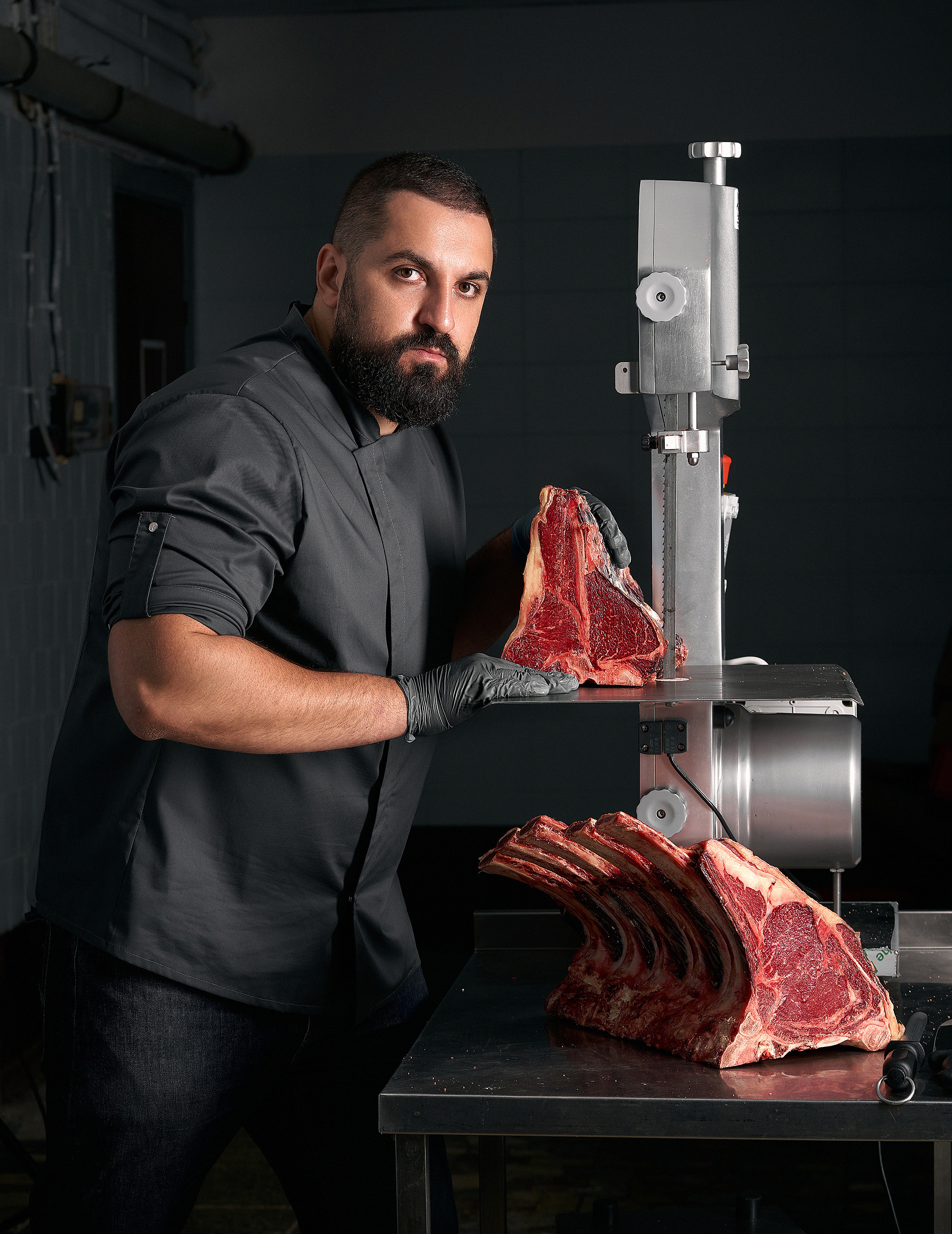 Мясник работает с мясом на производстве