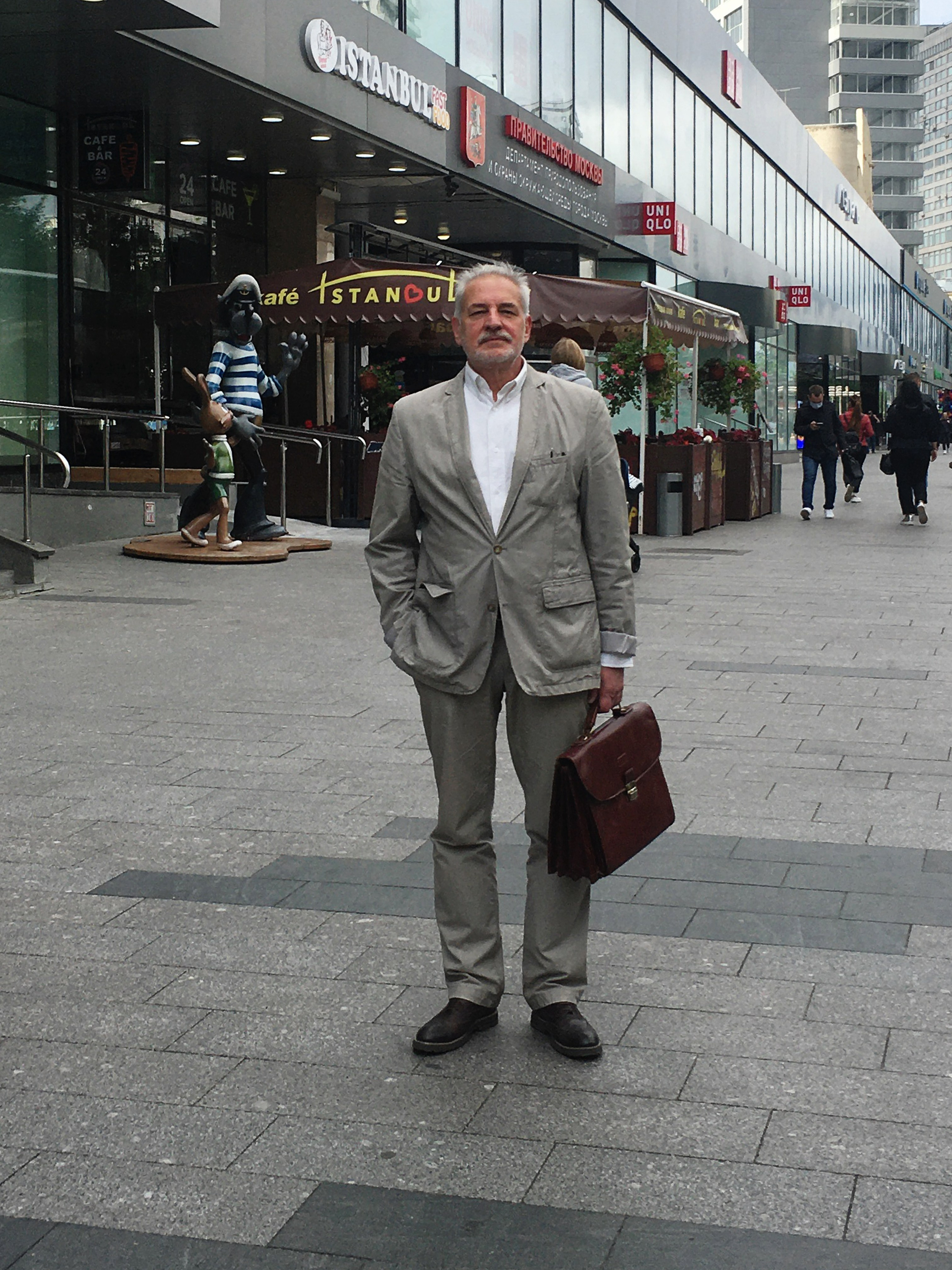 Новый арбат г. Москва. Адвокат Восканян Микита Михайлович в сером костюме с портфелем на улице.  