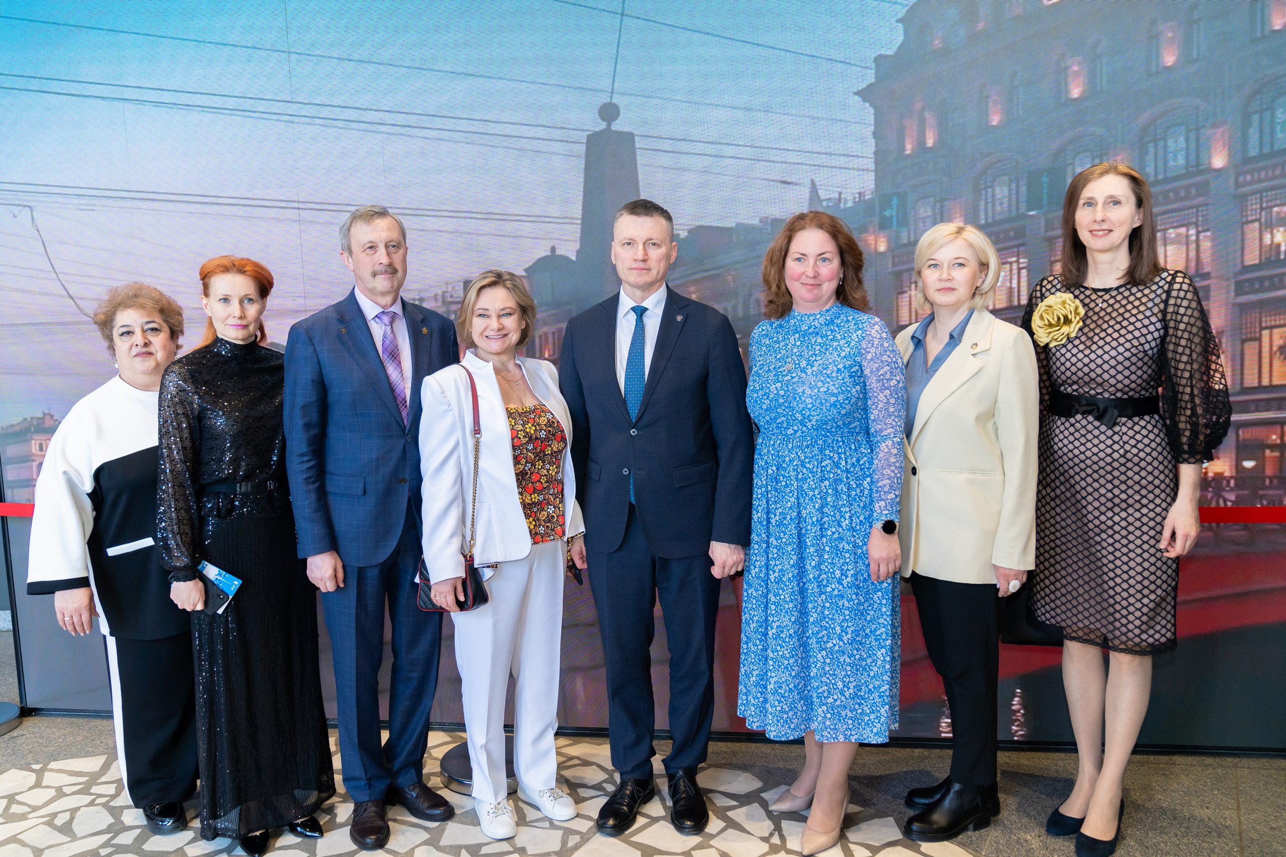 Коллективное фото участников и гостей Дня местного самоуправления Санкт-Петербург. Группа из восьми человек на фоне панорамы города. Фото Евгения Мальцева.