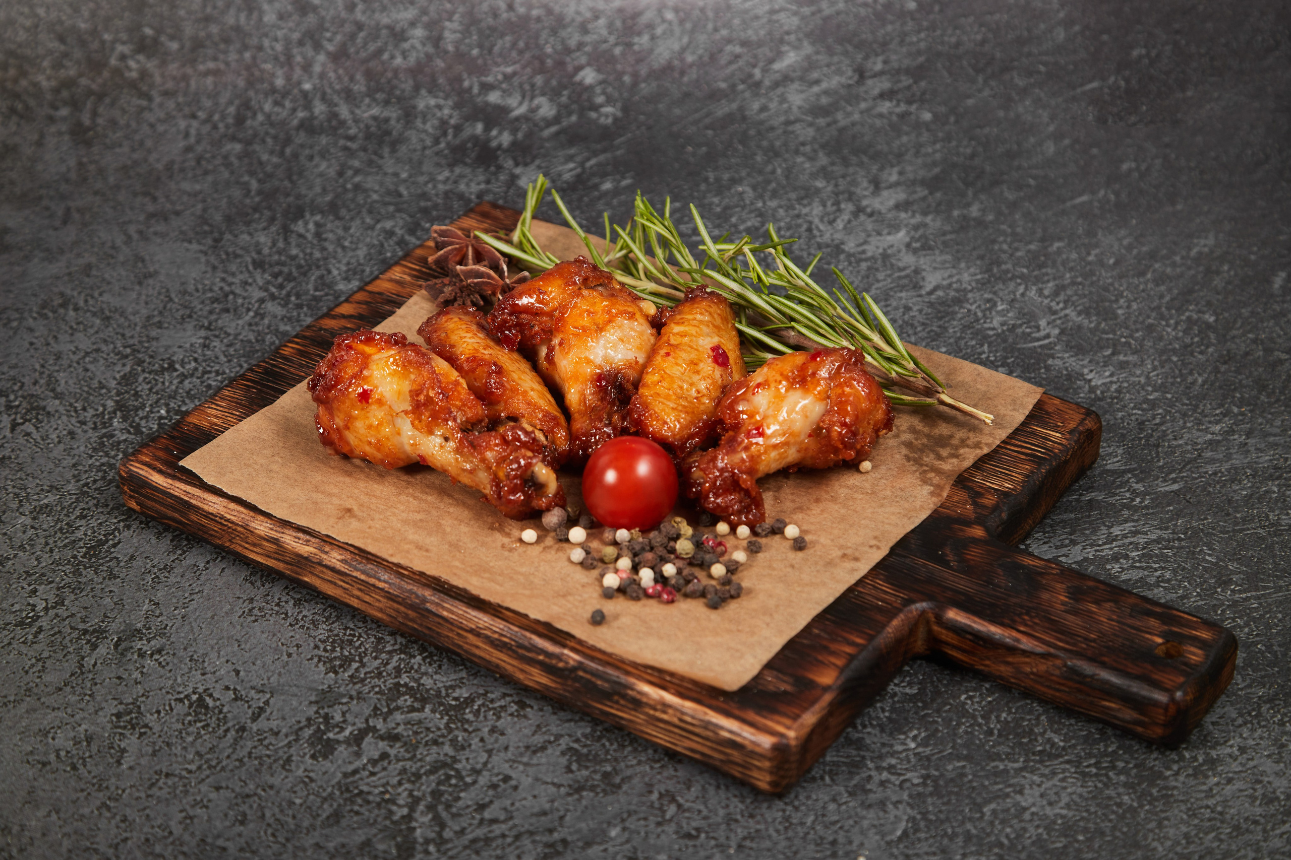 Жареные овощи на деревянной доске с зеленью.