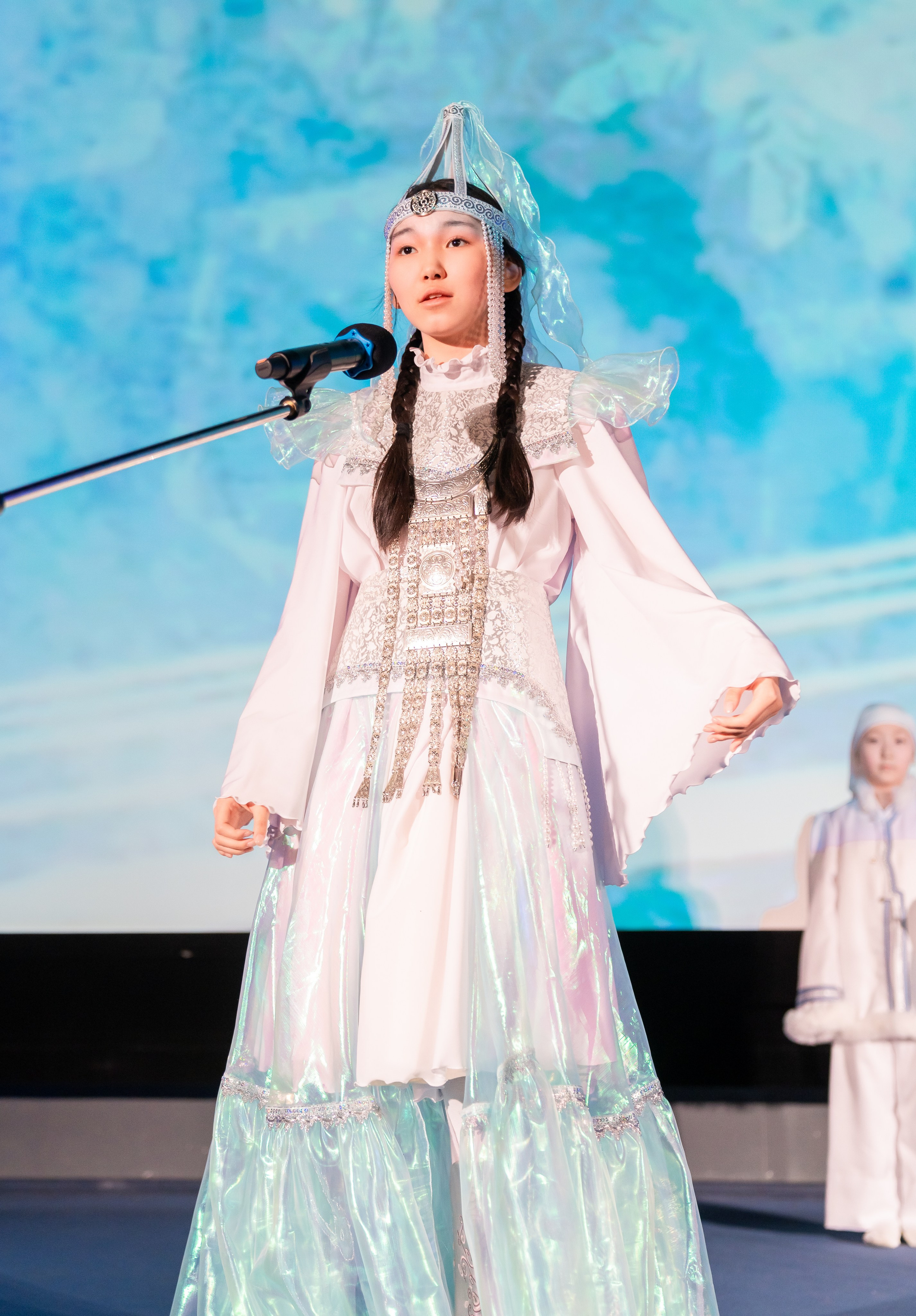 евушка в традиционном белом костюме народов Севера поёт на XII Международном фольклорном фестивале «Сохраняем традиции» Санкт-Петербург 2026. Фото: Мальцев Евгений, evrednix.ru.