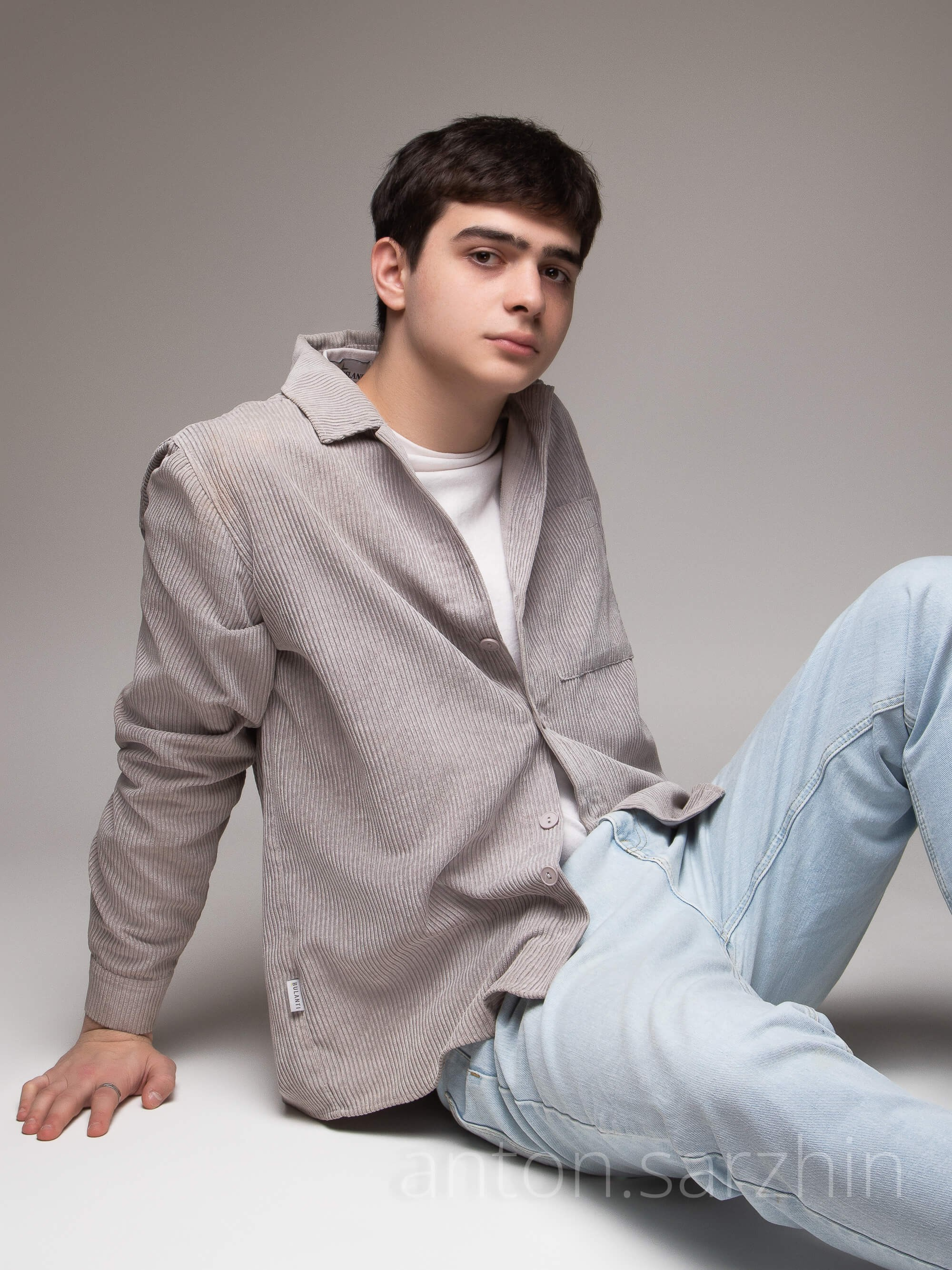 Студийная съемка парня на полу в студии