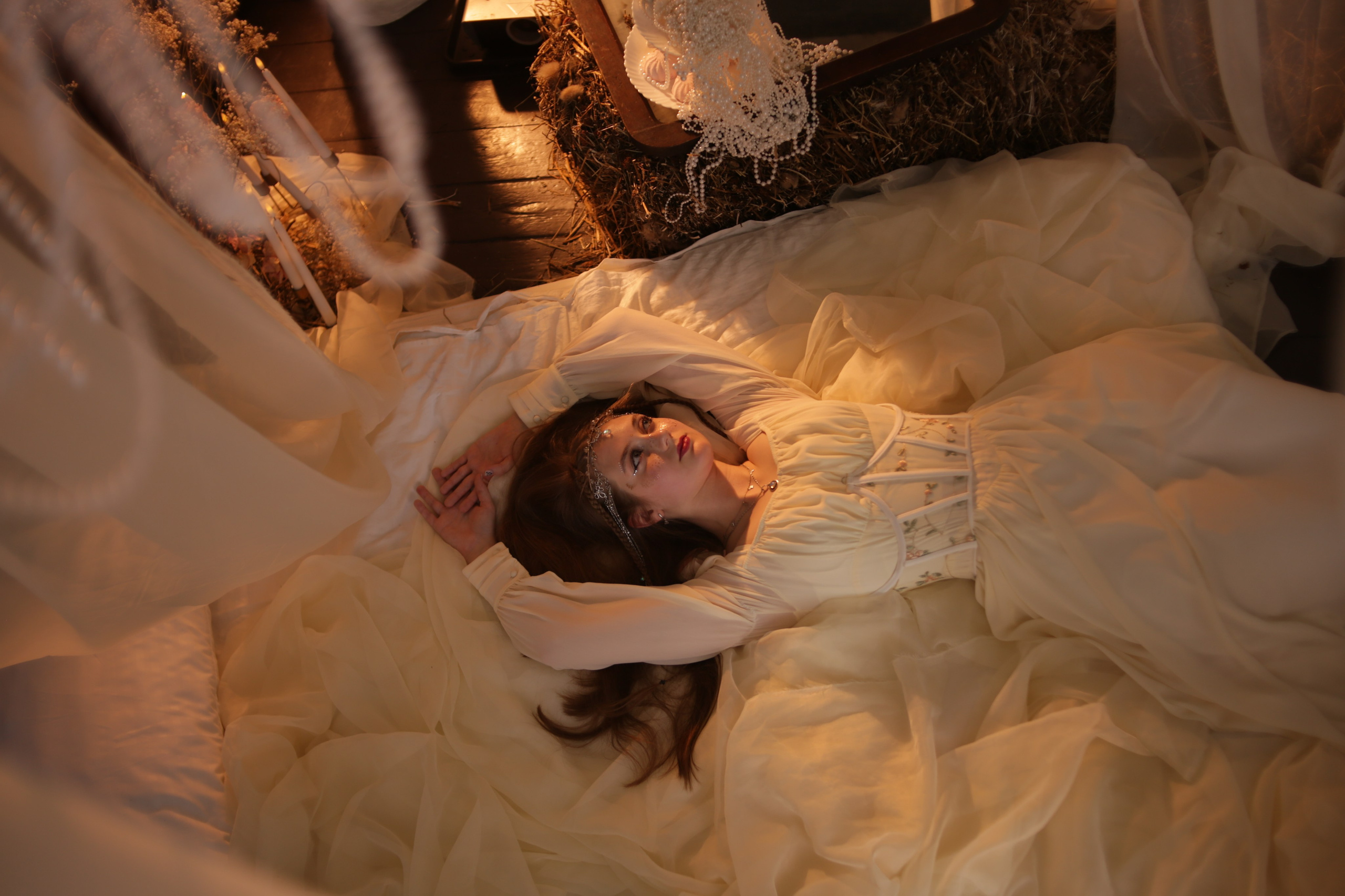 Необычная фотосессия в Перми: девушка в белом платье спит на кровати под балдахином, лицо украшено блестками