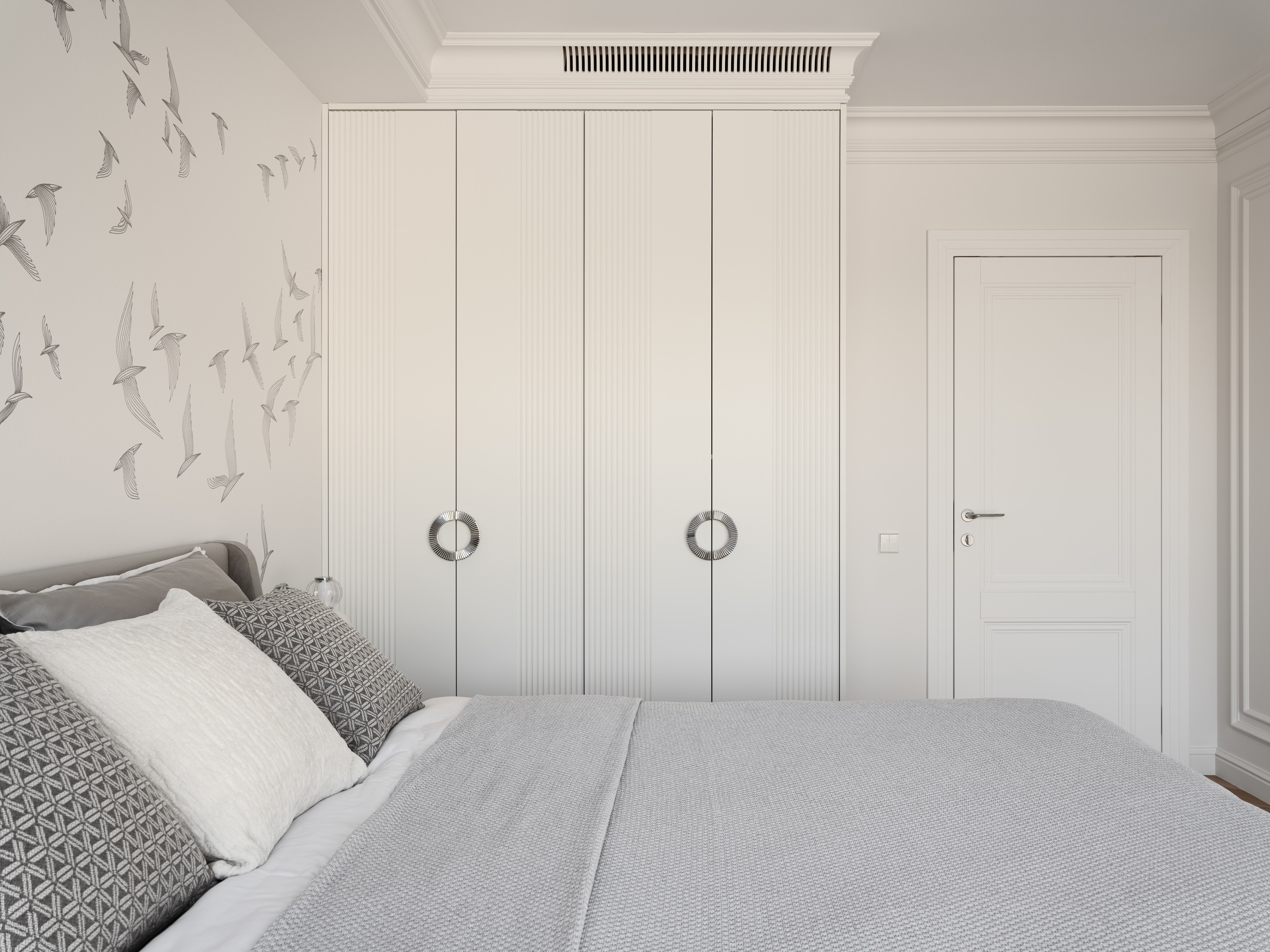 Вид на спальню с кроватью, декором в виде летящих птиц и встроенным гардеробом с рифлёными фасадами, созданный дизайнером Алёной Боярской. Стилист Наталья Якушева продумала сочетание светлых оттенков, а фотограф Сергей Денисенко точно передал эстетику минимализма.