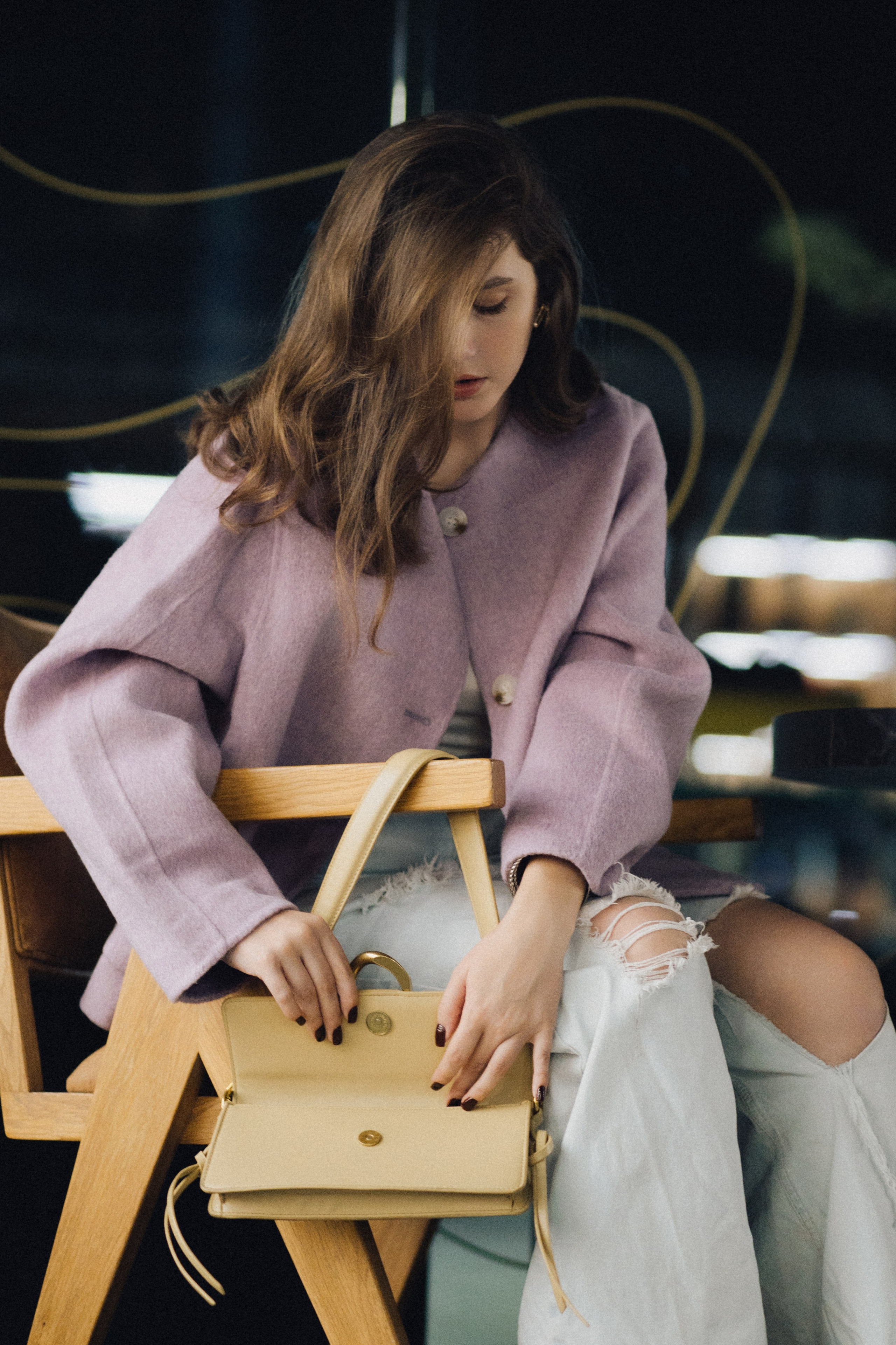 Девушка в сиреневом жакете и рваных джинсах открывает желтую сумку в кафе. Фотограф в Пензе Александра Овечкина