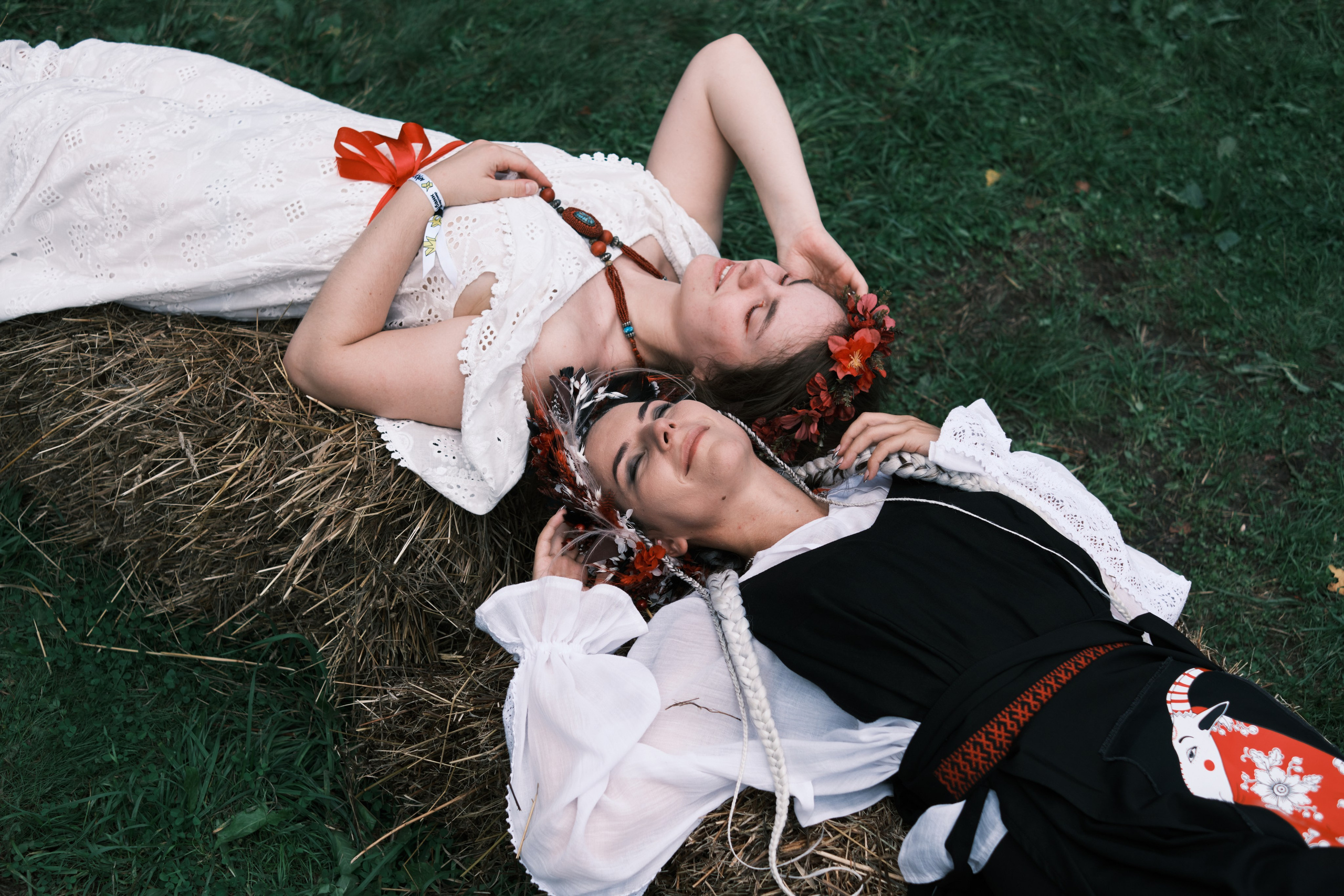Девушки лежат на сене в костюмах в русском стиле