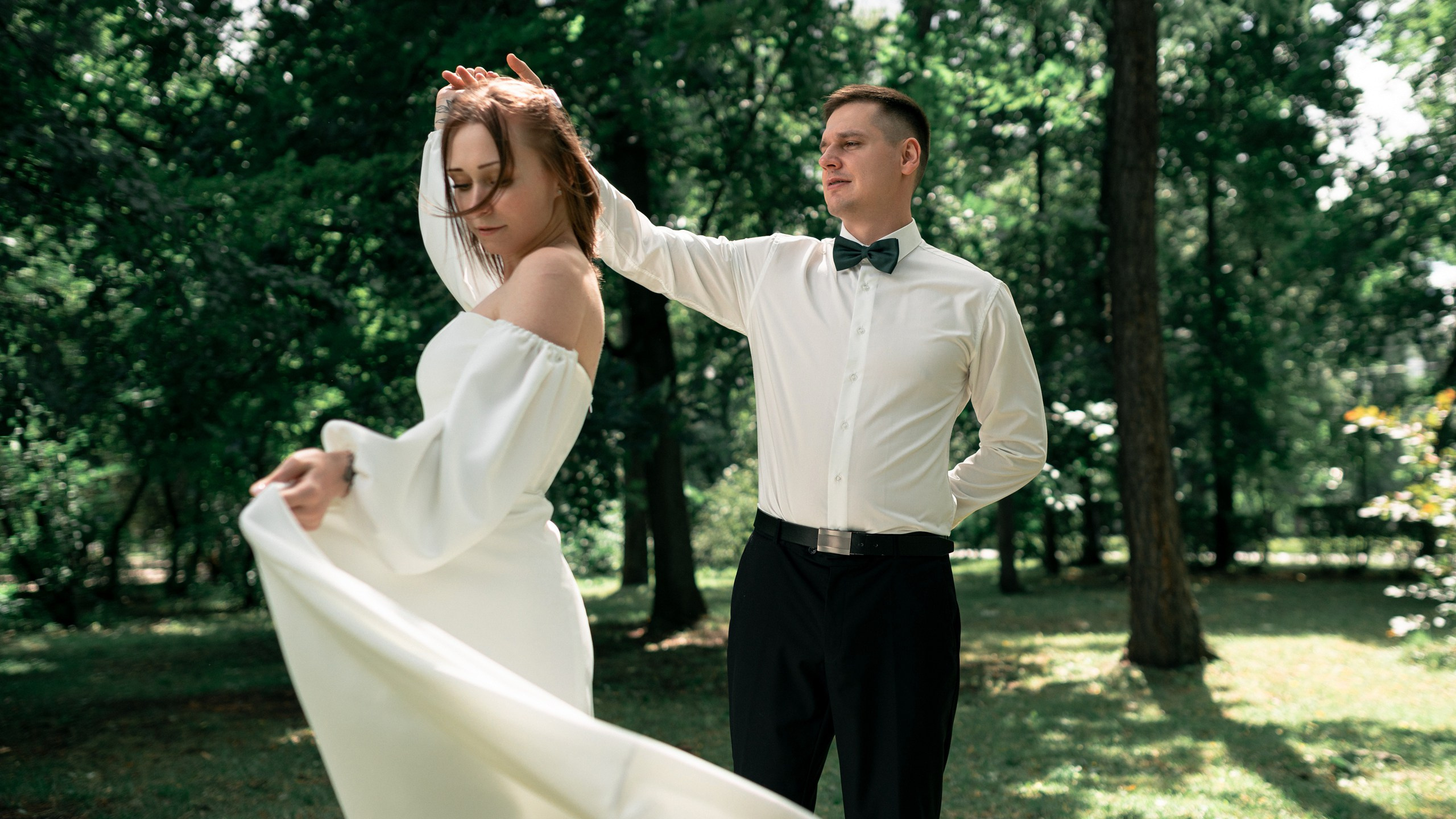 Молодожёны танцуют на свадьбе в зелёном саду 