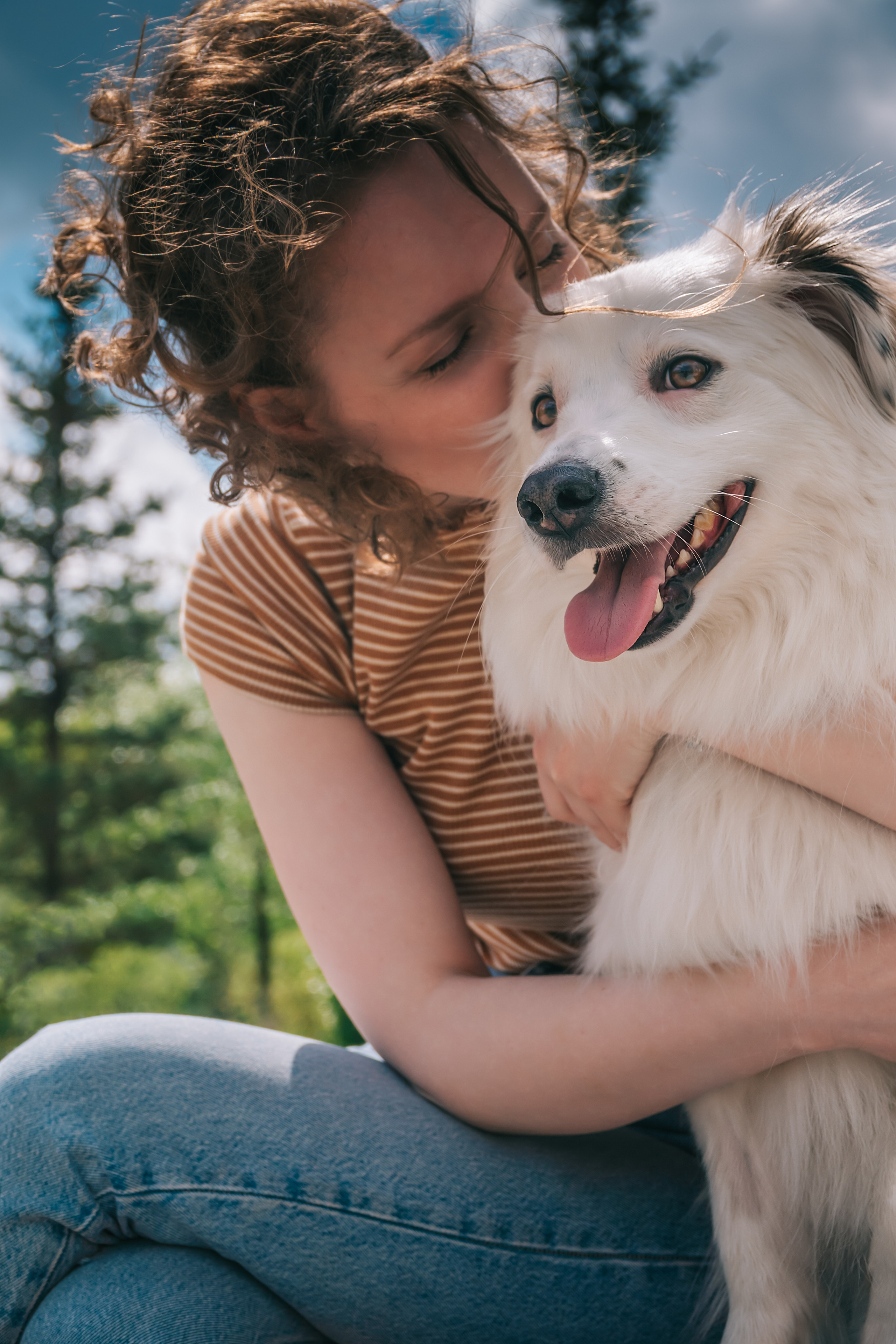 Девушка обнимает и целует свою собаку