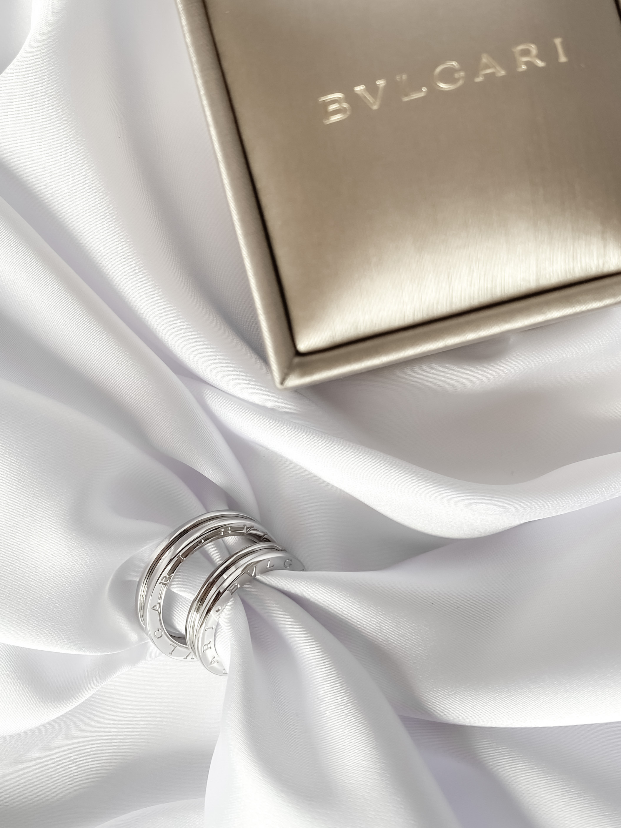 обручальные кольца bulgari с футляром на белом фоне