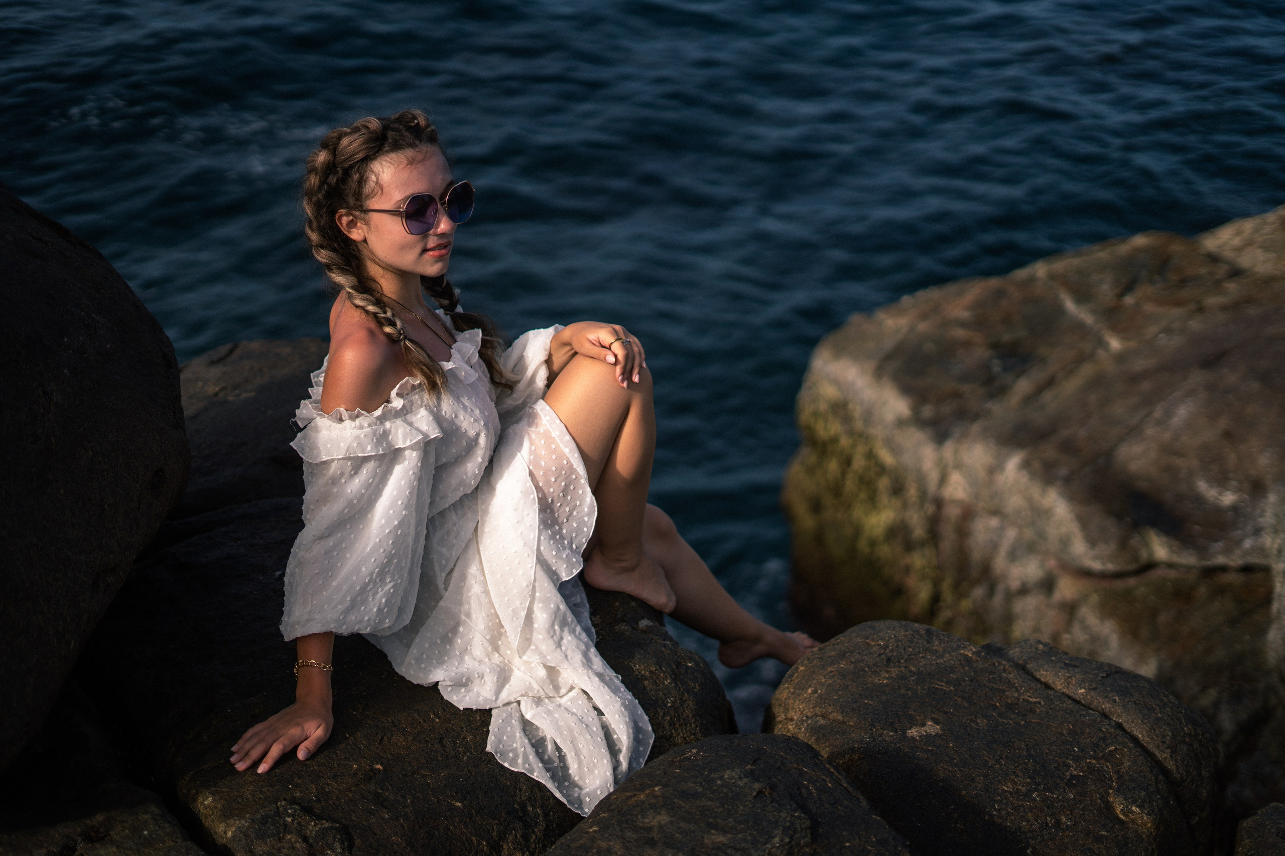 a young girl in a white dress and glasses with bright sunlight
