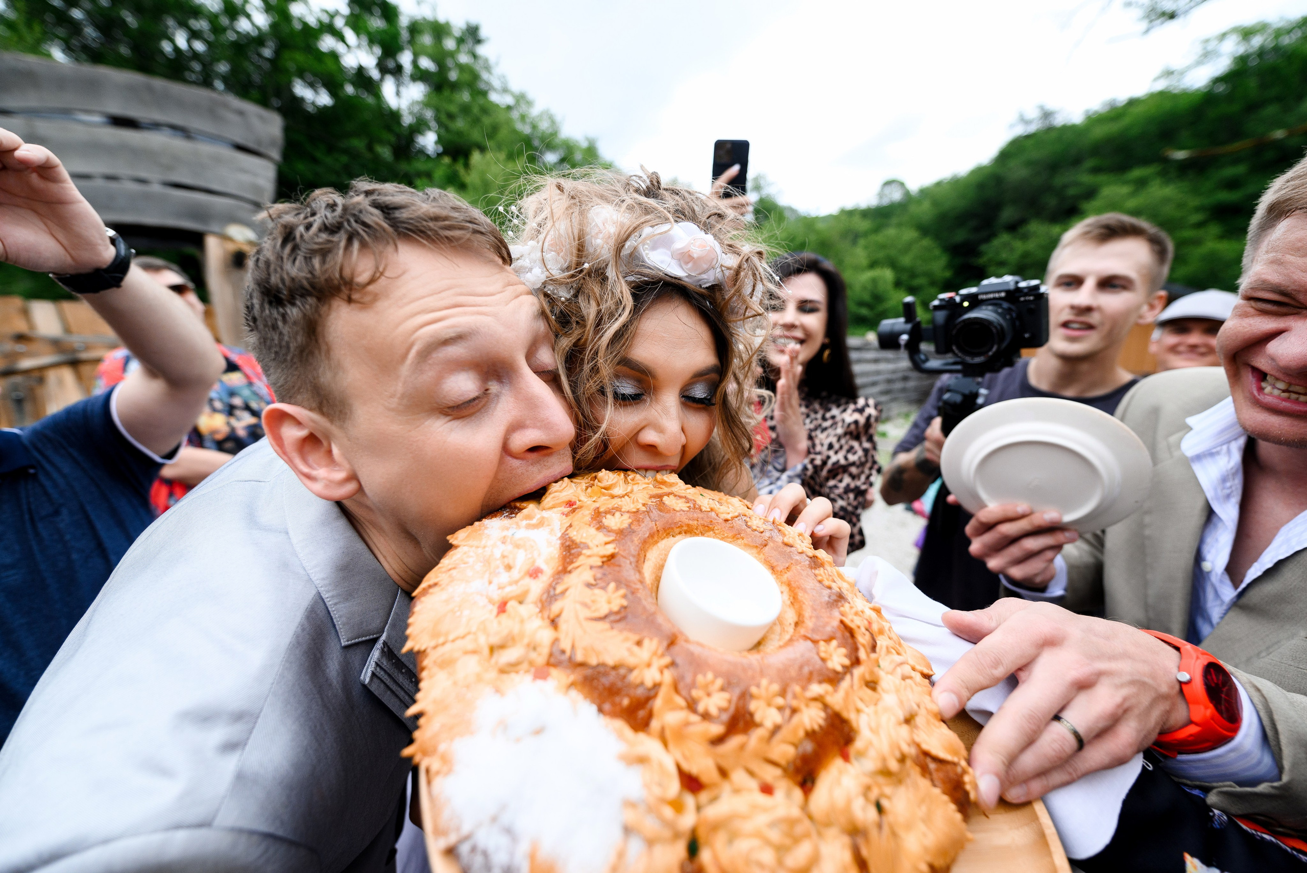 Свадебная церемония с элементами стиля 90-х, что привнесет в вашу свадьбу особую атмосферу жених с невестой откусывает каравай кто больше откусит  вокруг гости 