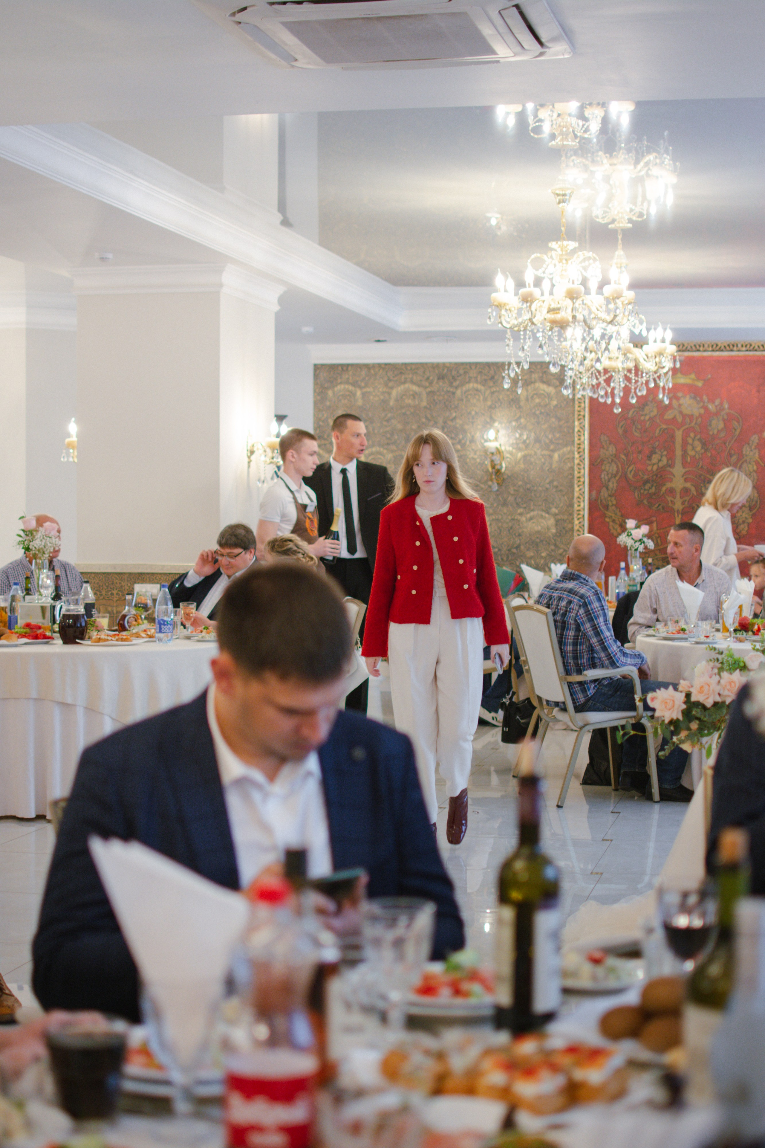 Гости свадьбы идут к своим местам за столами