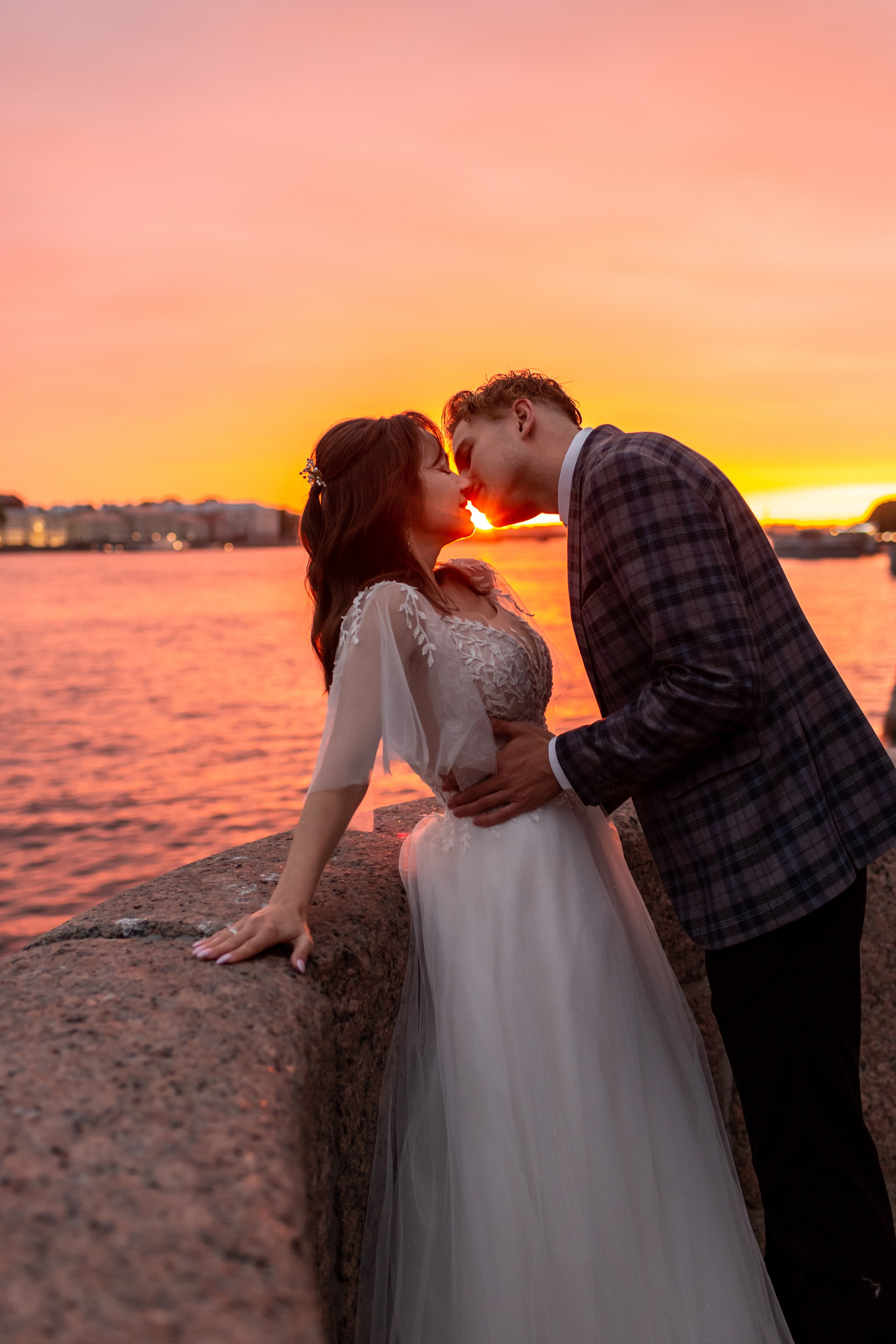 Фотосессия на рассвете в Петербурге: молодожены в белые ночи целуются на набережной.