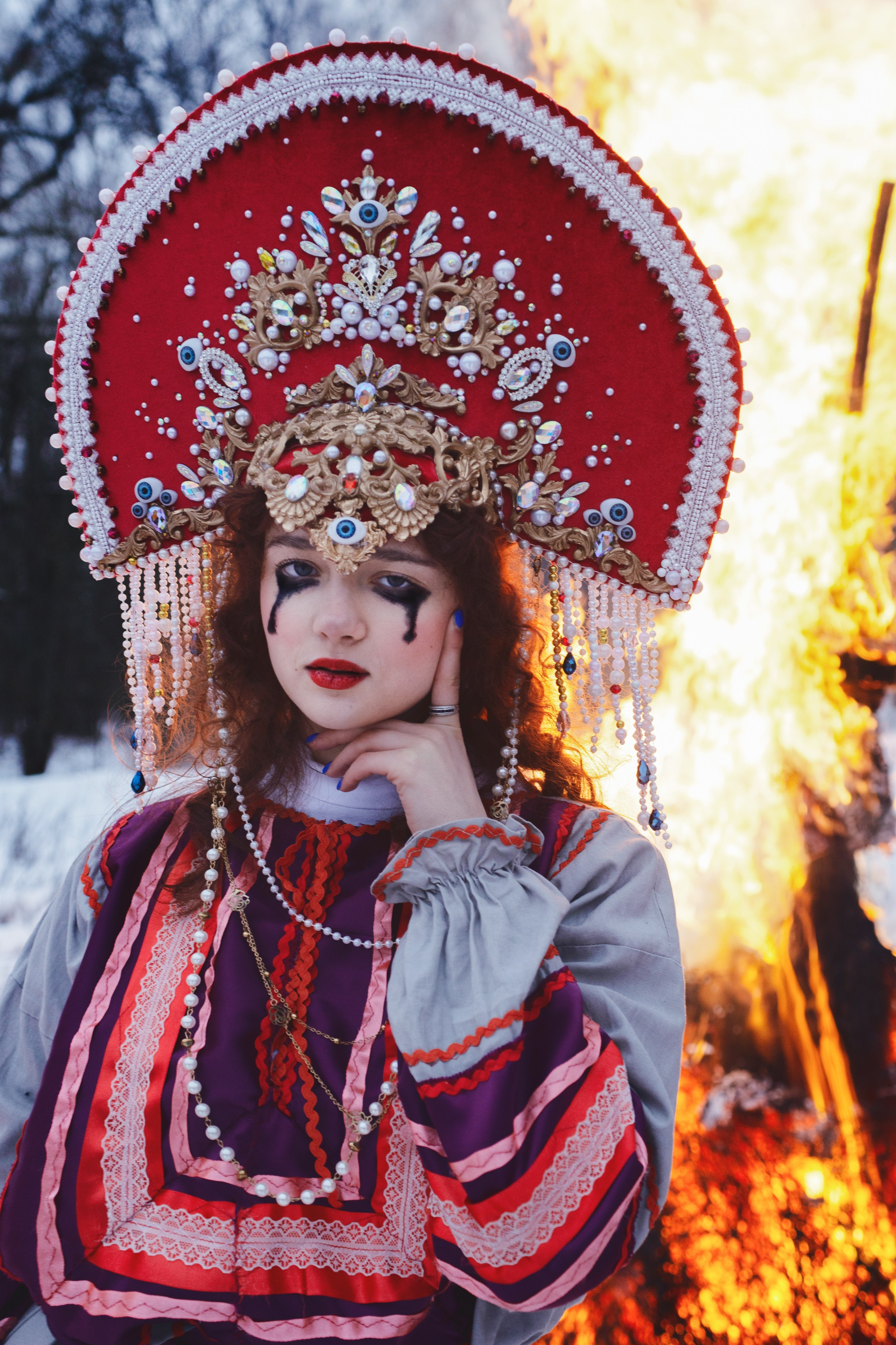 Девушка в русском-народном костюме зимой на масленицу на фоне костра 