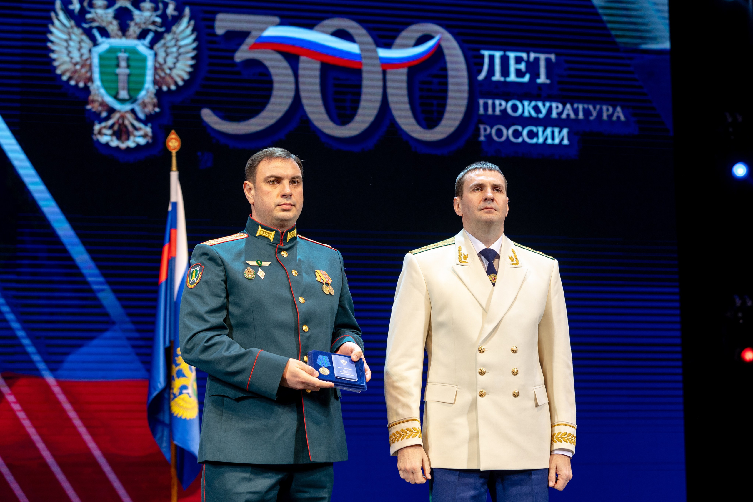 Награждённый участник у знамён на сцене — торжественный портрет, фотограф СПб