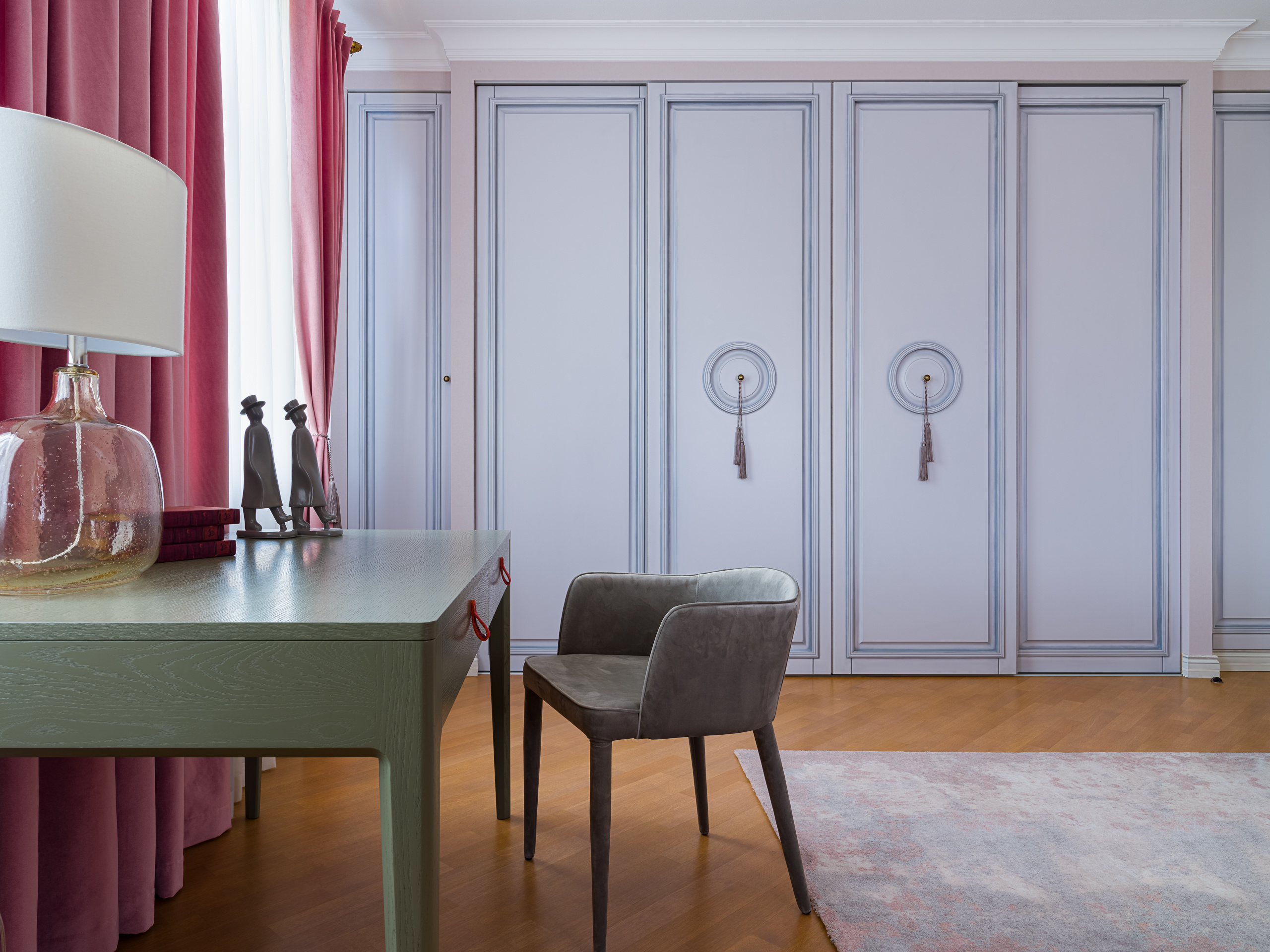 Интерьер спальни с встроенными шкафами пастельного оттенка, серым креслом и столом у окна с розовыми шторами. Уравновешенная цветовая палитра от дизайнеров Германа Фарени и Надежды Крецкой. Фото Сергея Денисенко.