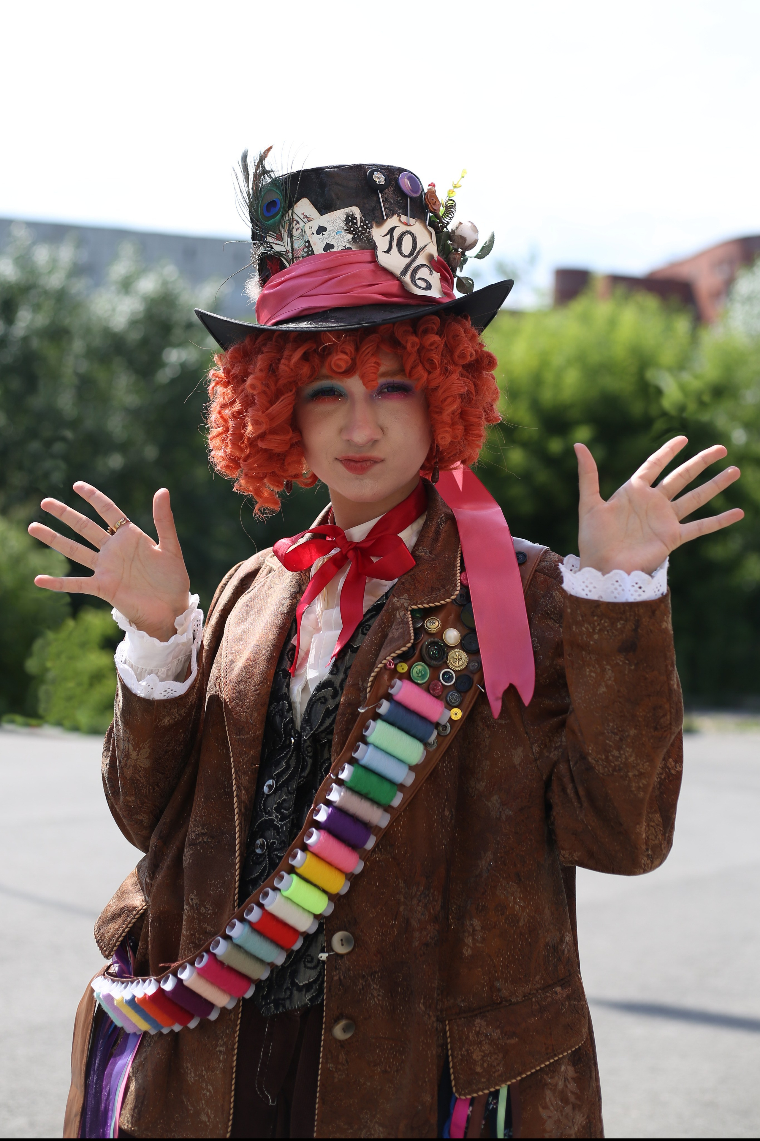 Портрет косплеера в костюме шляпника на фоне зелени