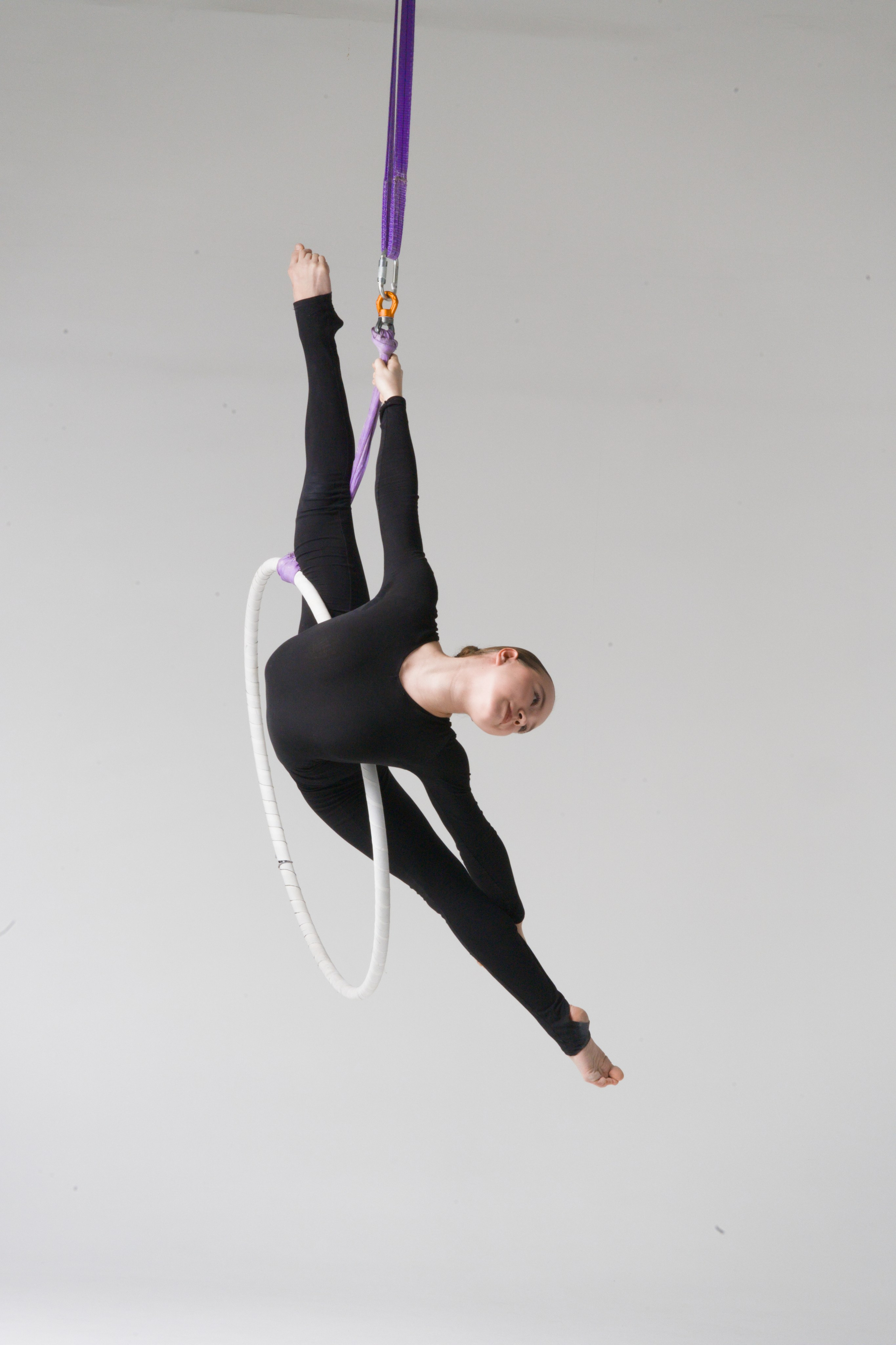 Сложный элемент гимнастки на вертикальном подвесе, чистота линий и грация юного атлета в стиле минимализм