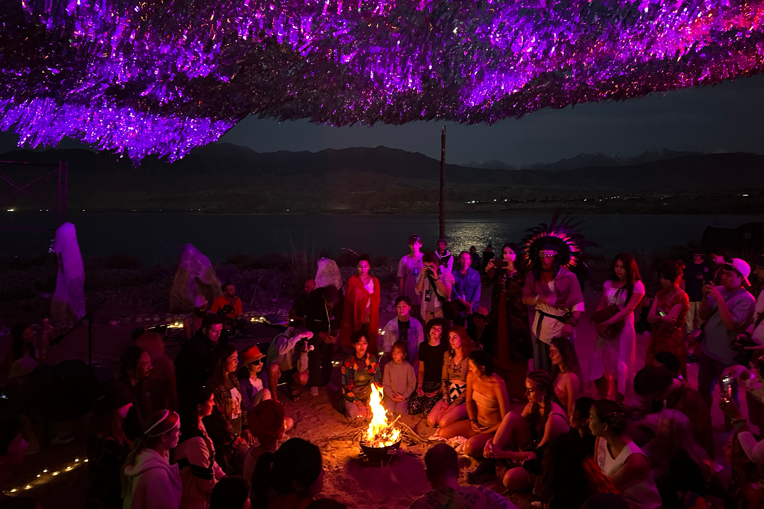 Люди у костра под арт-объектом Чебак развели костёр Көлфест